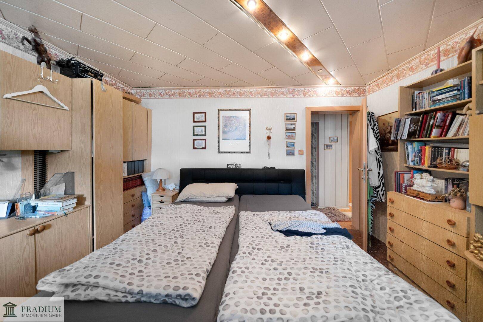 Gemütliches Schlafzimmer mit Doppelbett, Einbauschränken und Holzdecke, bietet viel Stauraum.