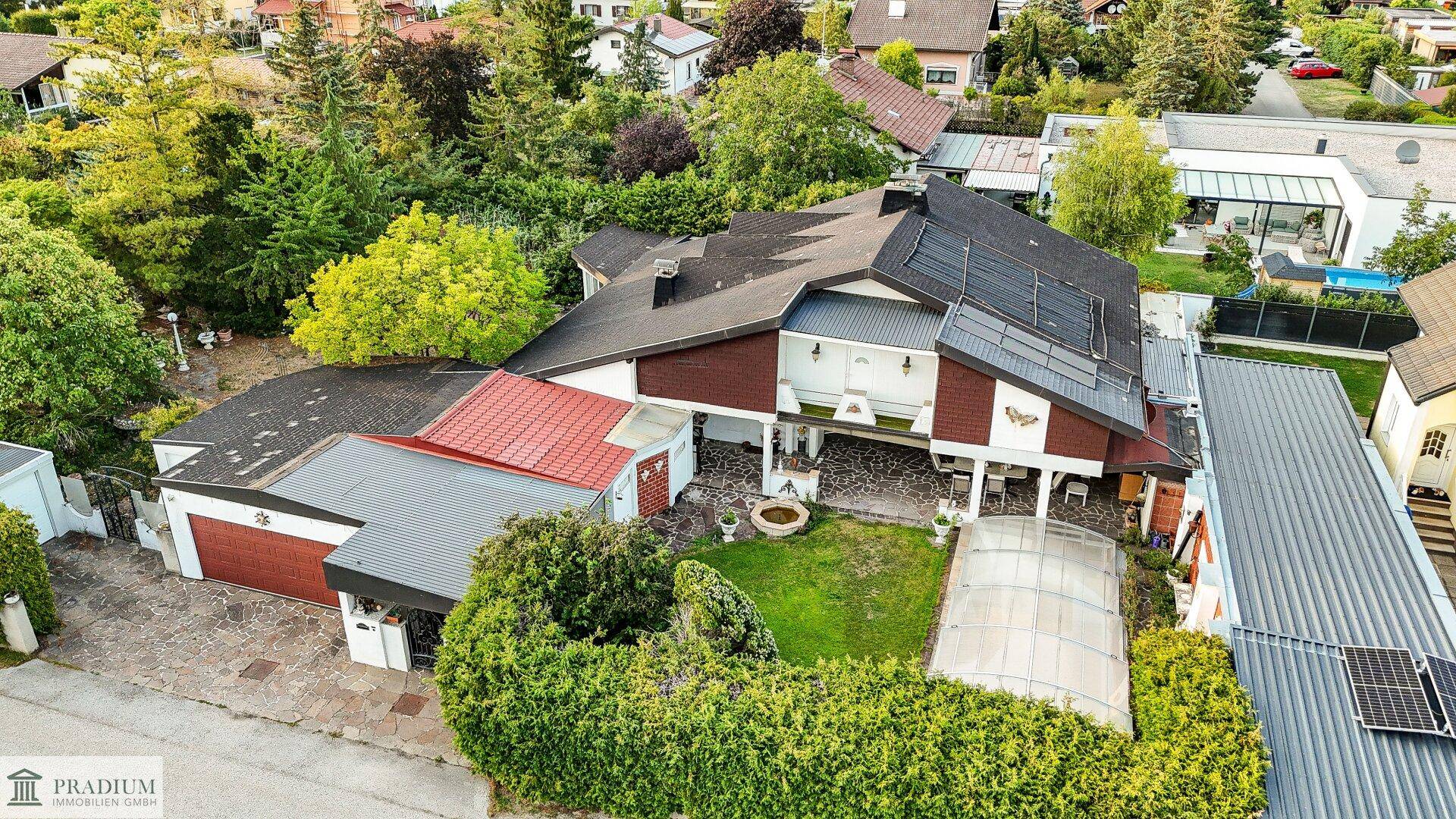 Übersichtliche Luftaufnahme des gesamten Anwesens mit Garten, Garage und Solaranlage auf dem Dach.