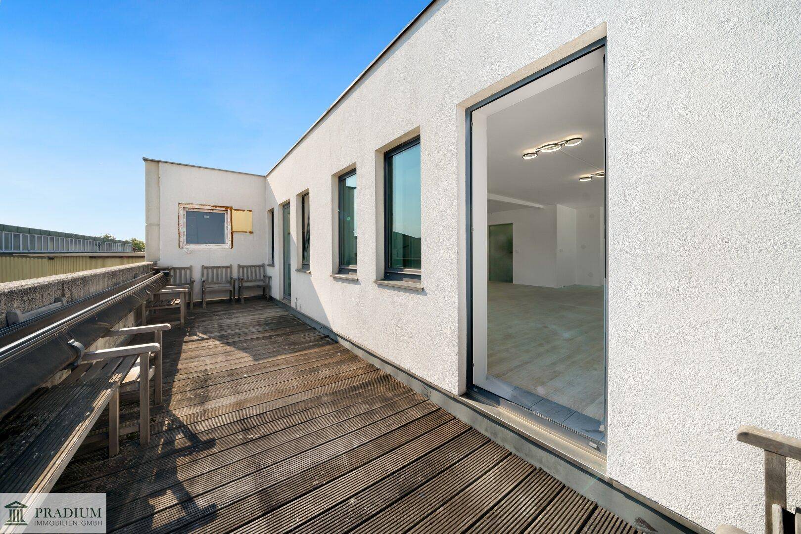 Große Dachterrasse mit Holzboden und Sitzgelegenheiten, ideal für Pausen im Freien.