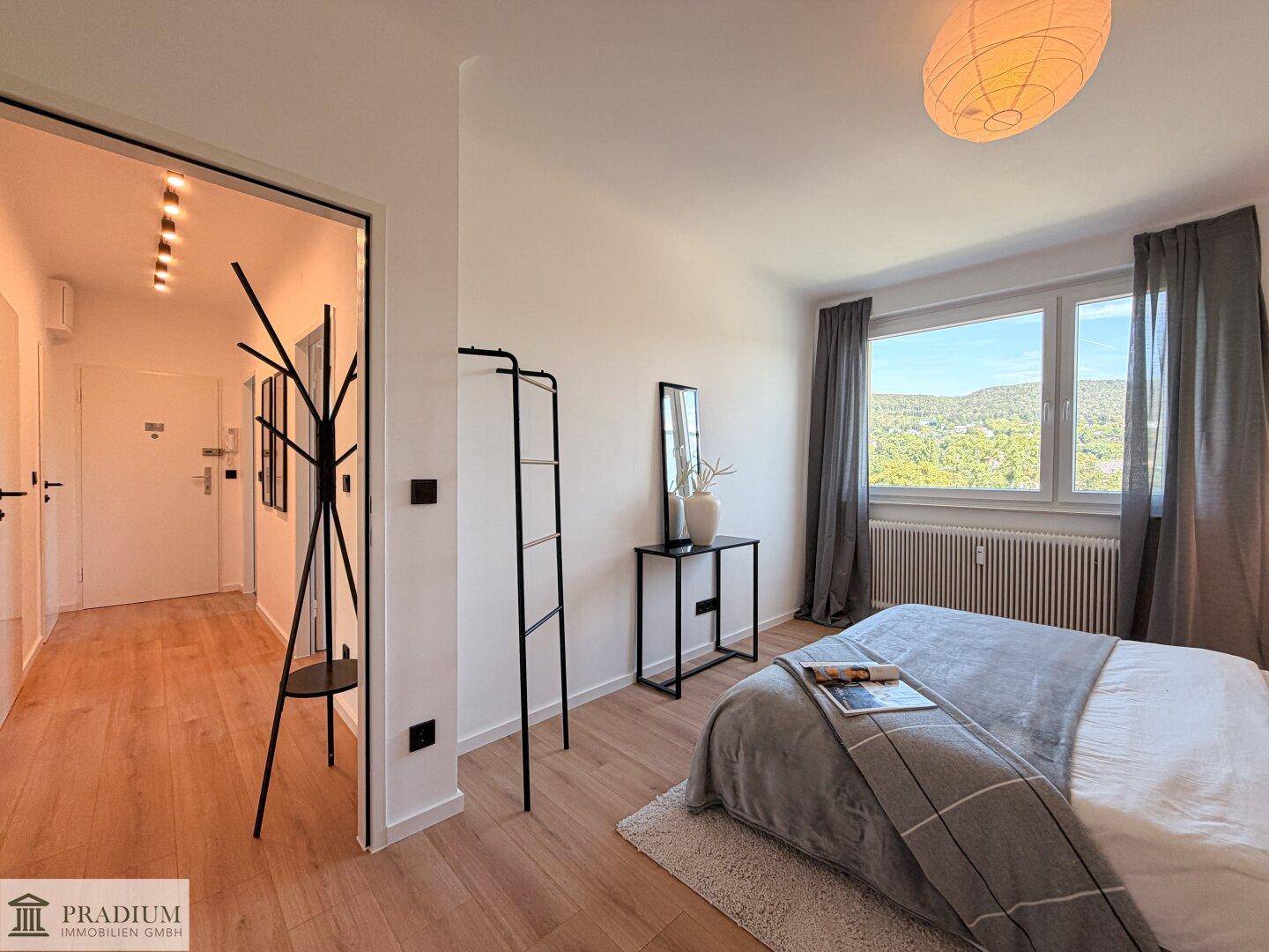 Schlafzimmer mit Zugang zum Flur, ausgestattet mit Holzboden und moderner Einrichtung.