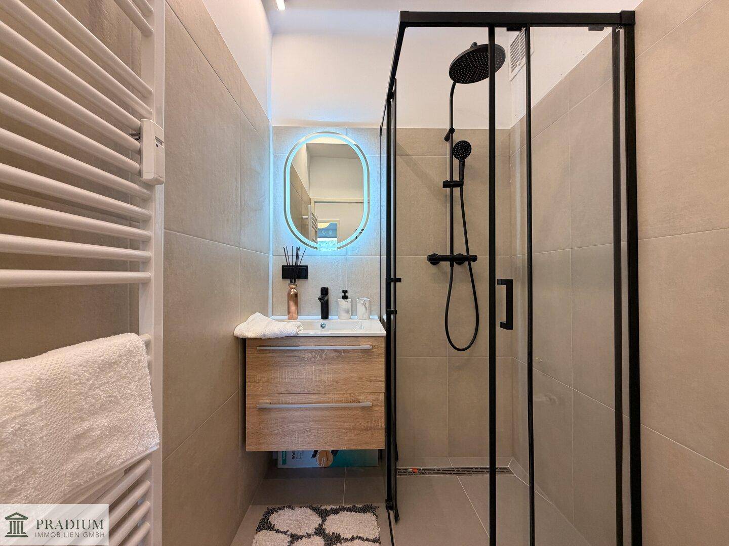 Modernes Badezimmer mit begehbarer Dusche, Einzelwaschbecken und beheiztem Handtuchhalter.