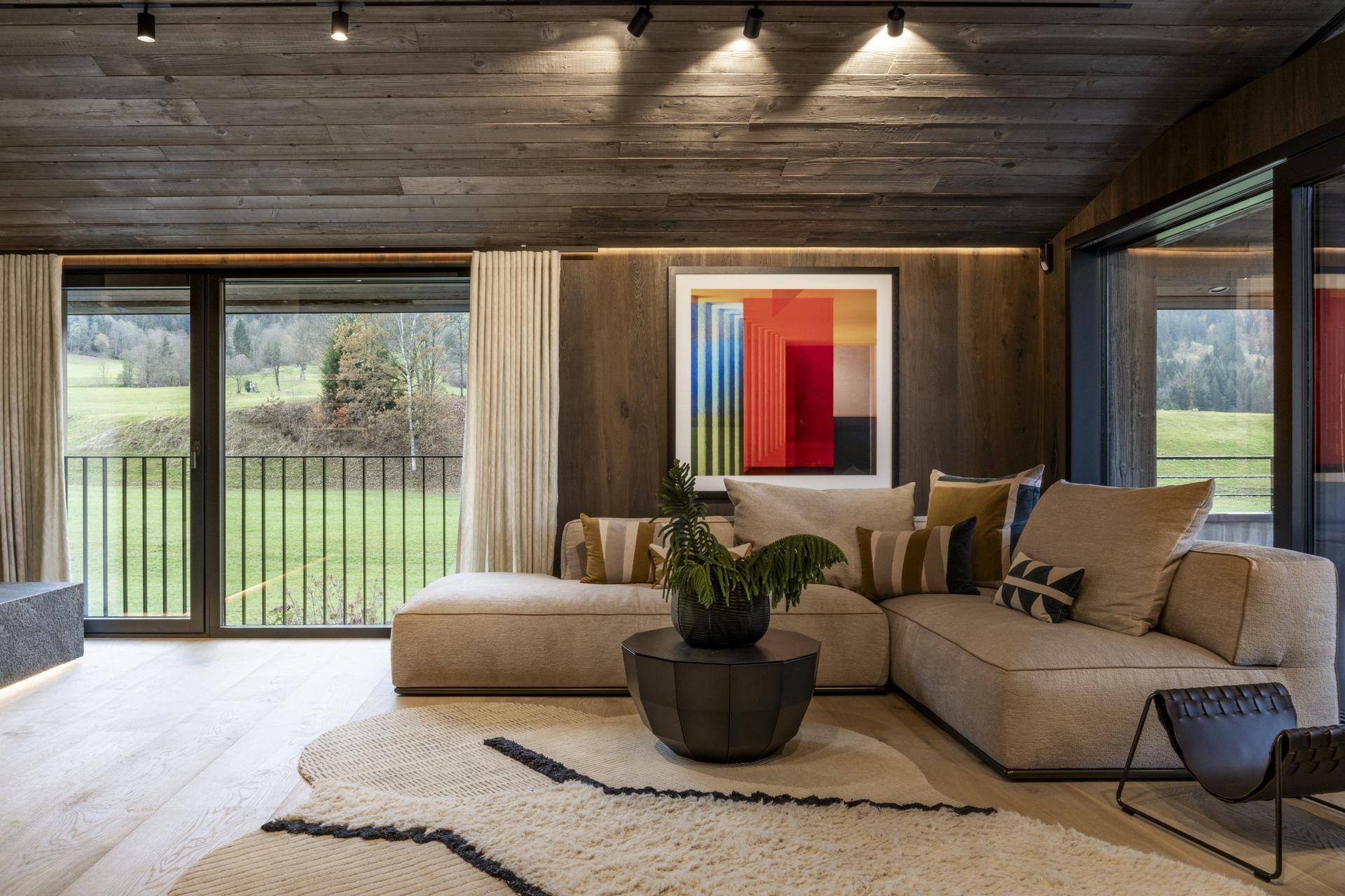Gemütliches Wohnzimmer mit Holzboden, bequemer Couch und moderner Kunst an der Wand.