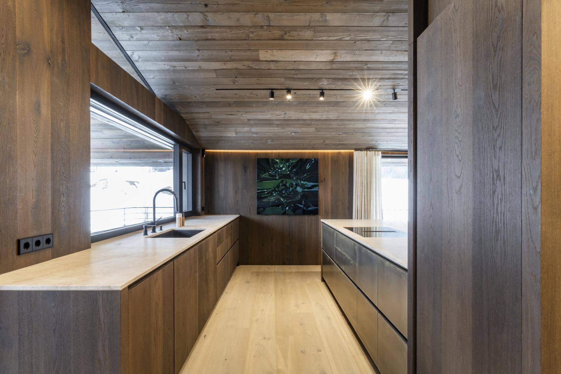 Moderne Küche mit Holzelementen, Stein-Arbeitsplatten und integrierten Geräten.