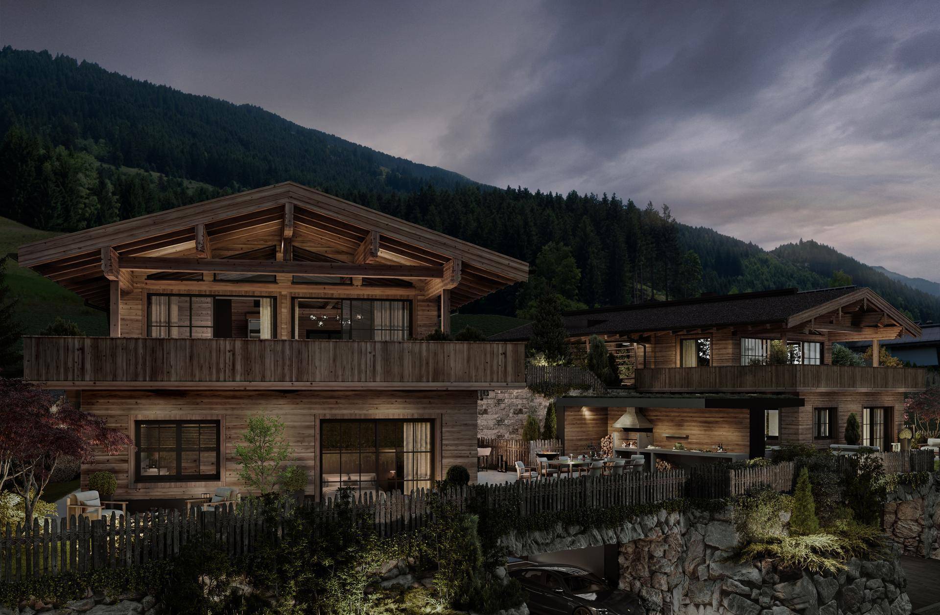 Luxuriöses Holzchalet bei Dämmerung mit beleuchteter Terrasse und Bergblick.