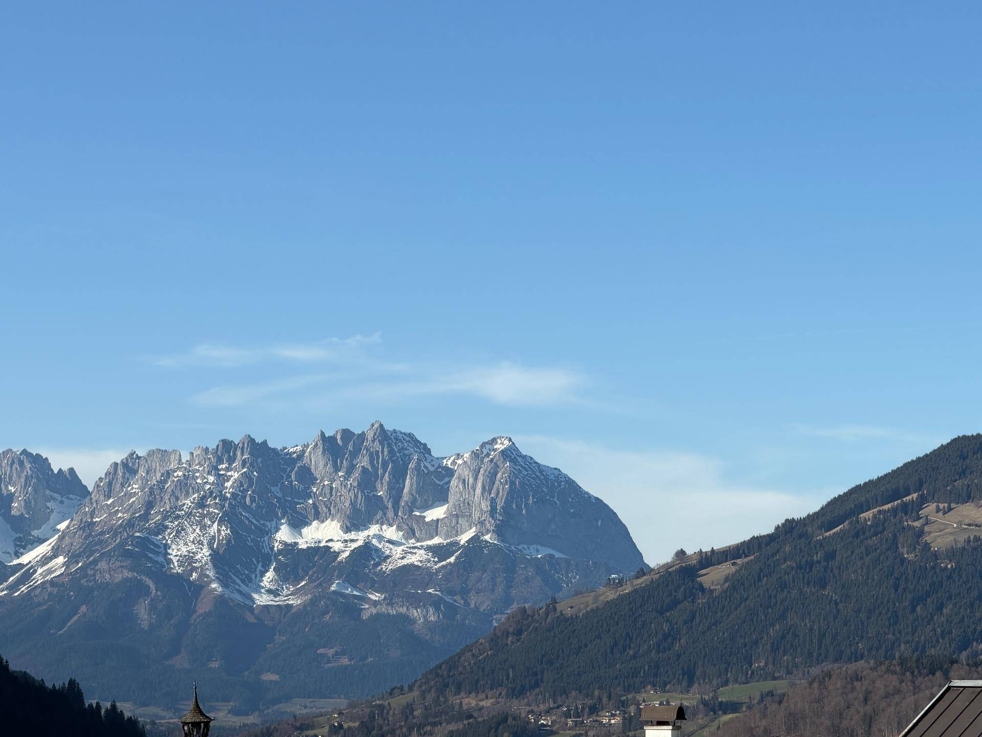 Atemberaubender Panoramablick auf majestätische, schneebedeckte Berggipfel unter blauem Himmel.