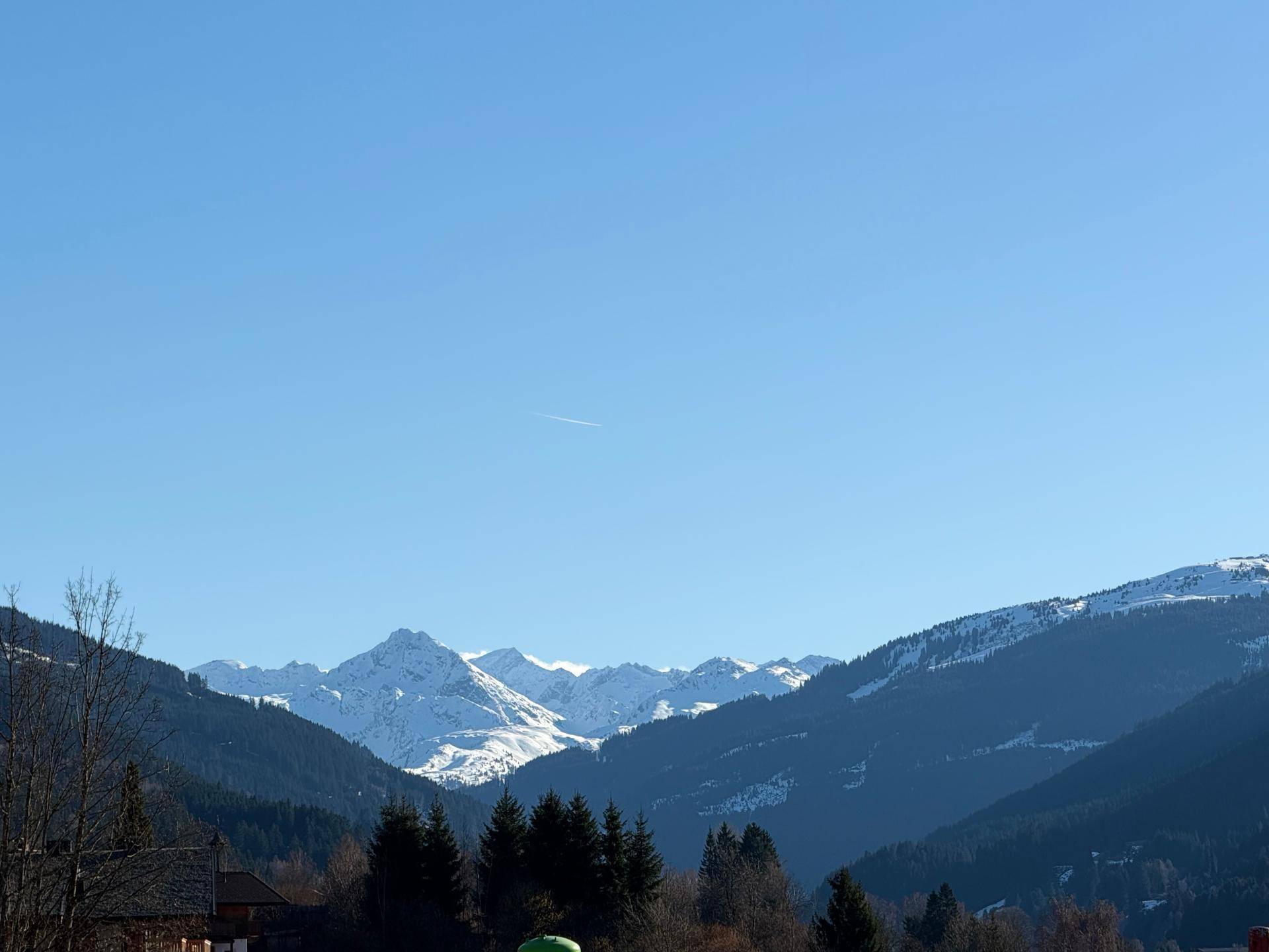 Weitläufiger Blick auf eine beeindruckende Bergkette mit schneebedeckten Gipfeln unter klarem Himmel.