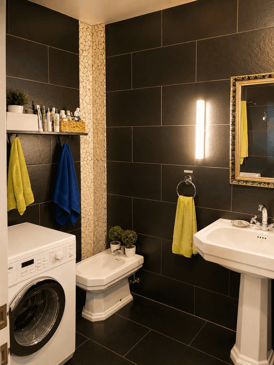 Modernes Badezimmer mit dunklen Fliesen, Waschmaschine, Bidet und Waschtisch.