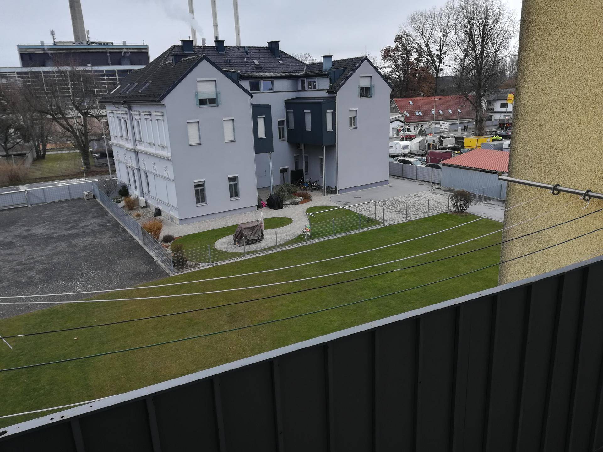 Weitläufige Außenansicht eines Wohngebäudes mit großem Rasenbereich und Blick auf die Umgebung.