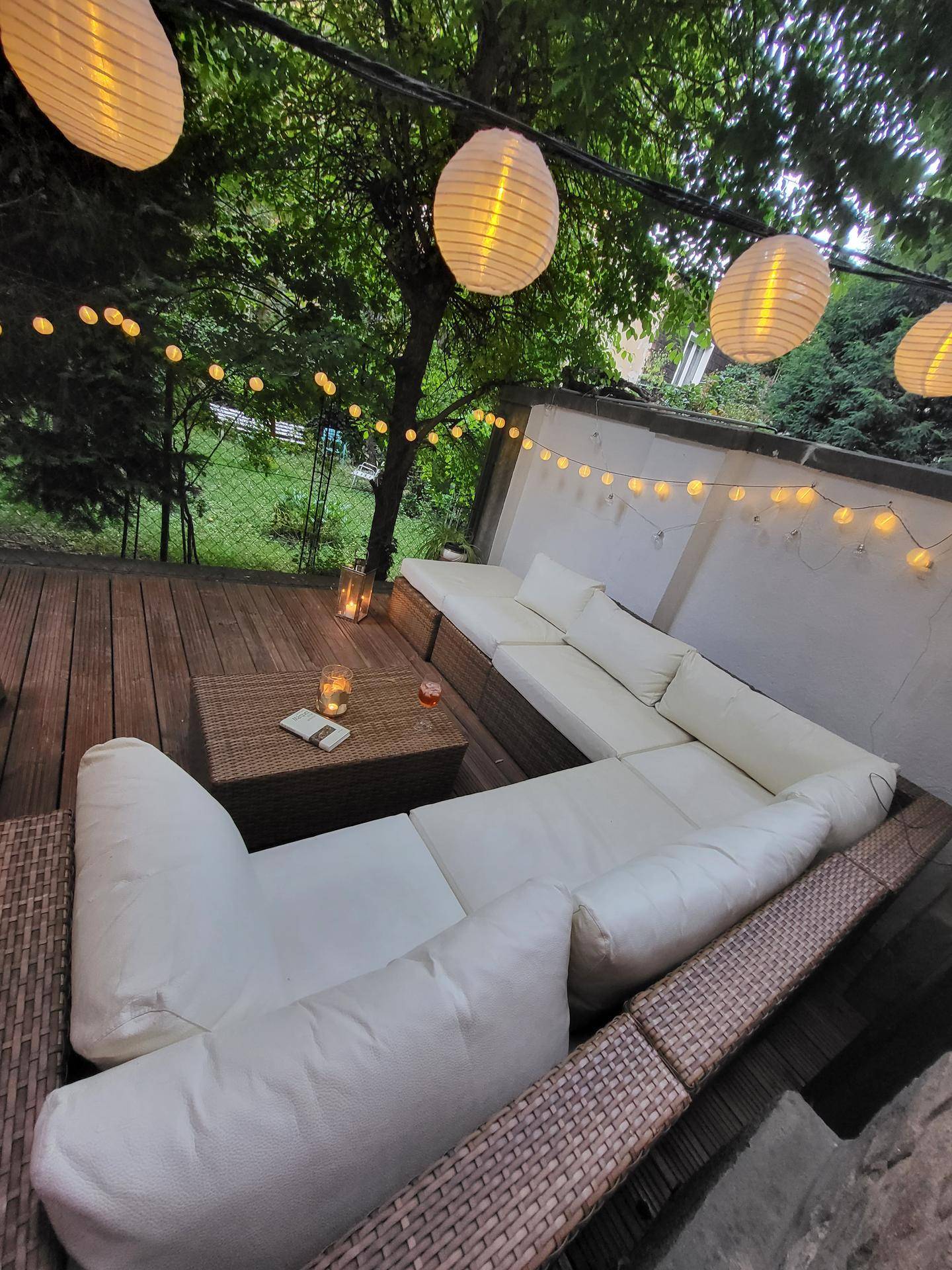 Entspannende Holzterrasse mit bequemen Lounge-Möbeln und stimmungsvoller Beleuchtung.