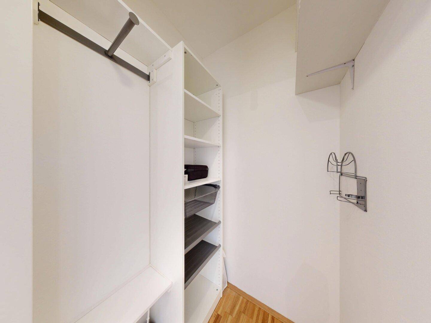 Praktischer begehbarer Kleiderschrank mit Regalen und Kleiderstange, bietet viel Stauraum.