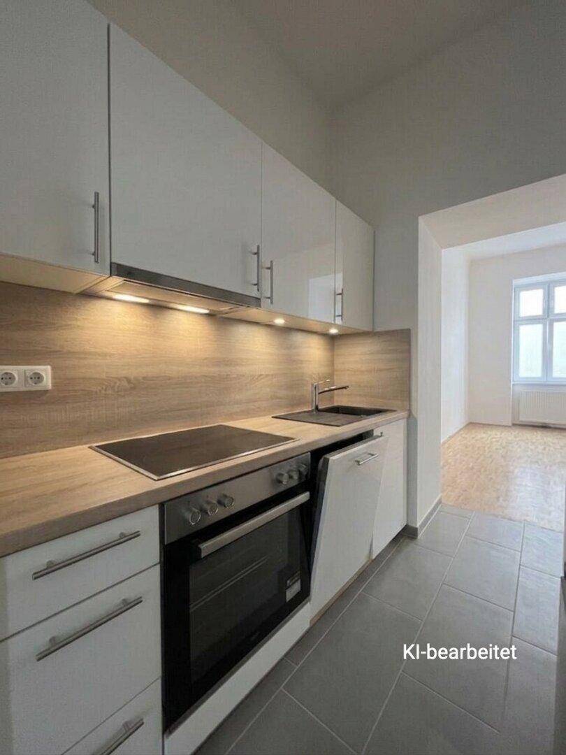 Moderne Einbauküche mit weißen Hochglanzschränken, integrierten Geräten und Fliesenboden.