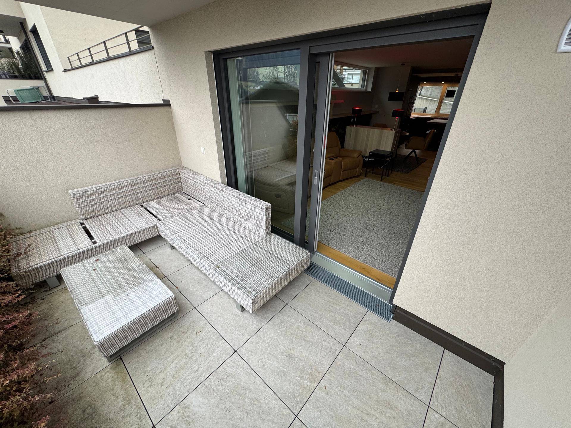 Möblierte Terrasse mit Lounge-Sofa und direktem Zugang zum Innenbereich des Hauses.