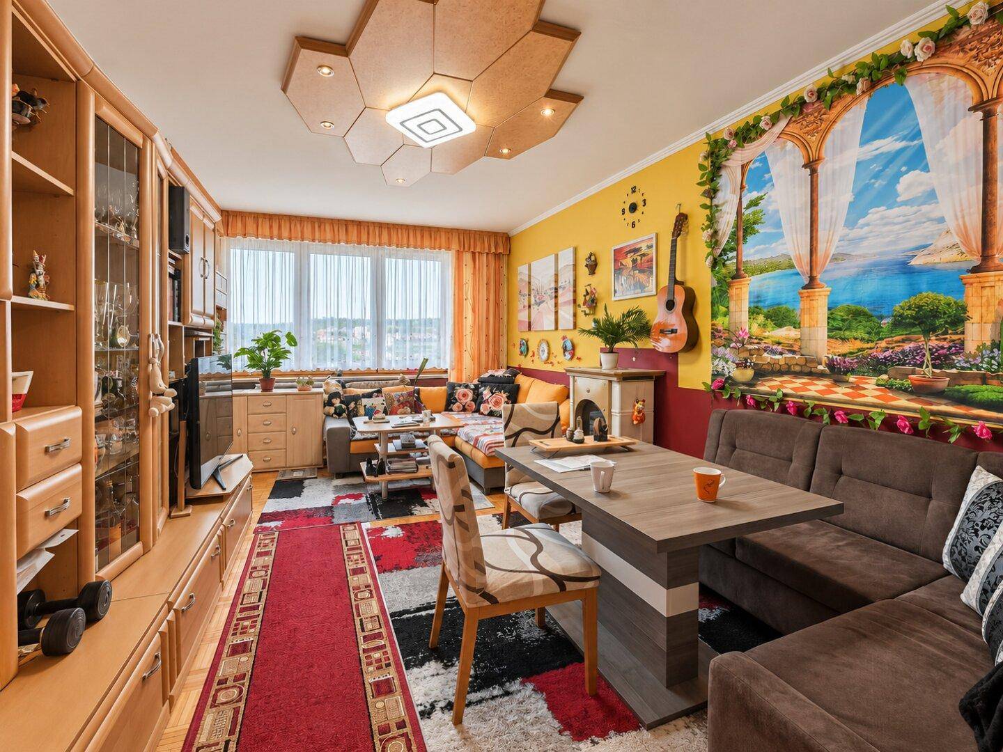 Geräumiger Wohn-Essbereich mit vielseitiger Dekoration, großem Fenster und gemütlicher Sitzecke.