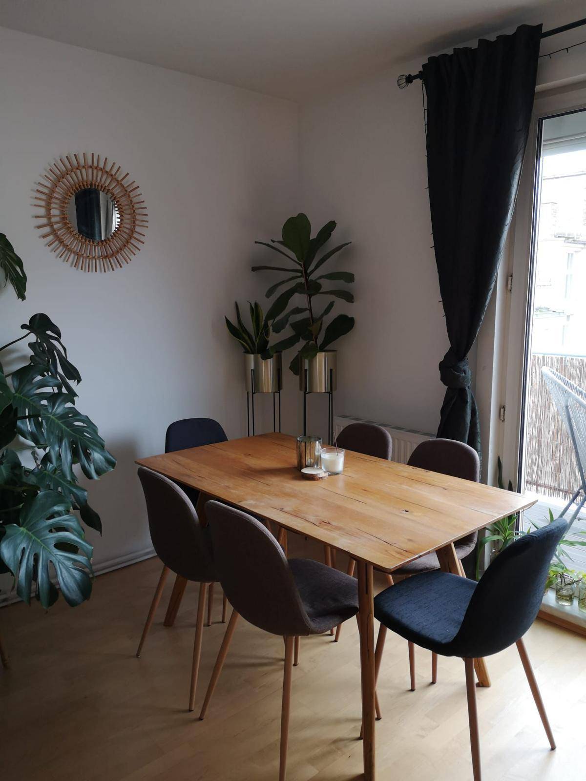 Essbereich mit Holztisch, modernen Stühlen und direktem Zugang zu einem Balkon.