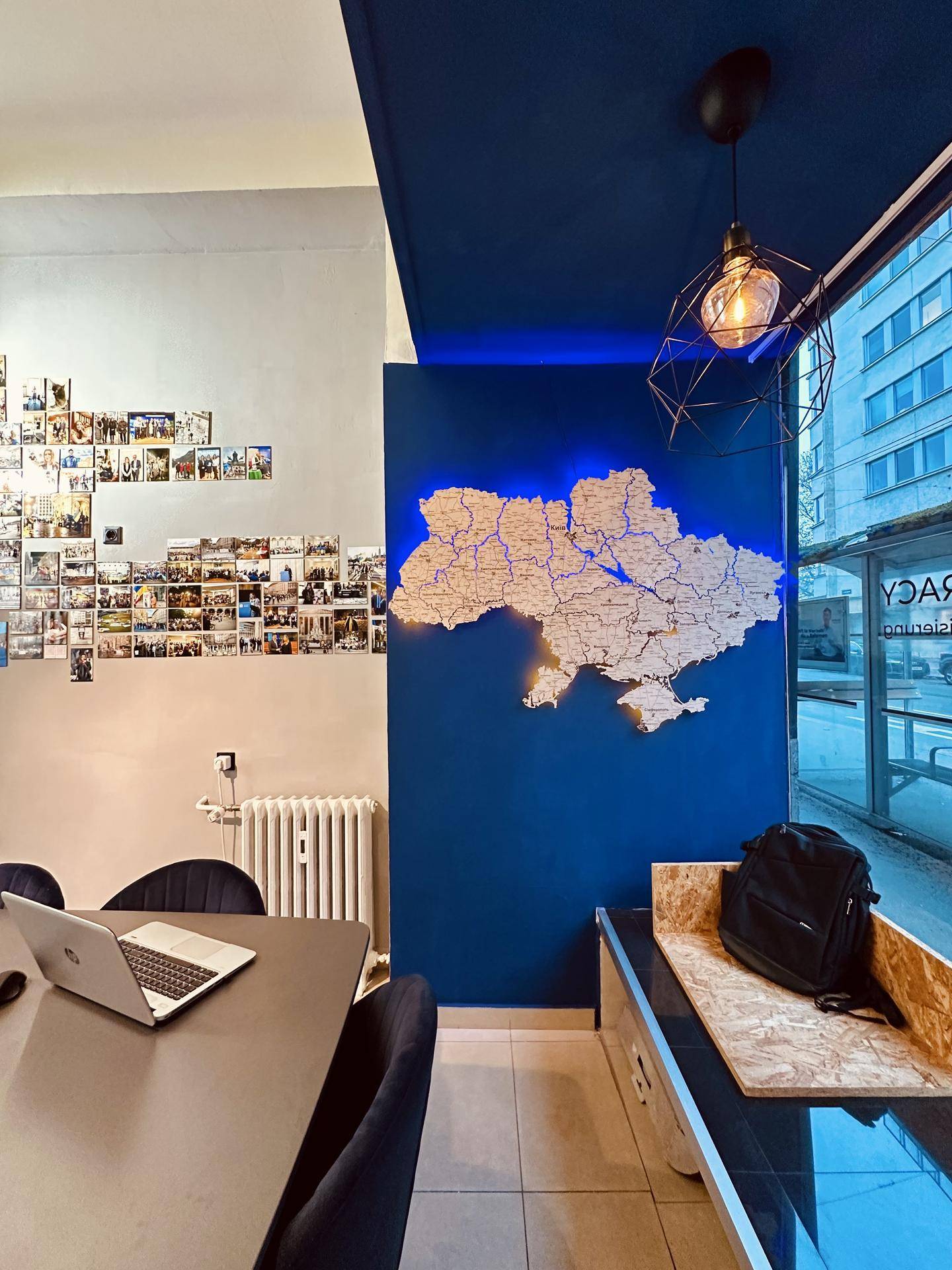 Büro- und Besprechungsraum mit beleuchteter Ukraine-Karte, großem Fenster und Blick auf die Stadtstraße.