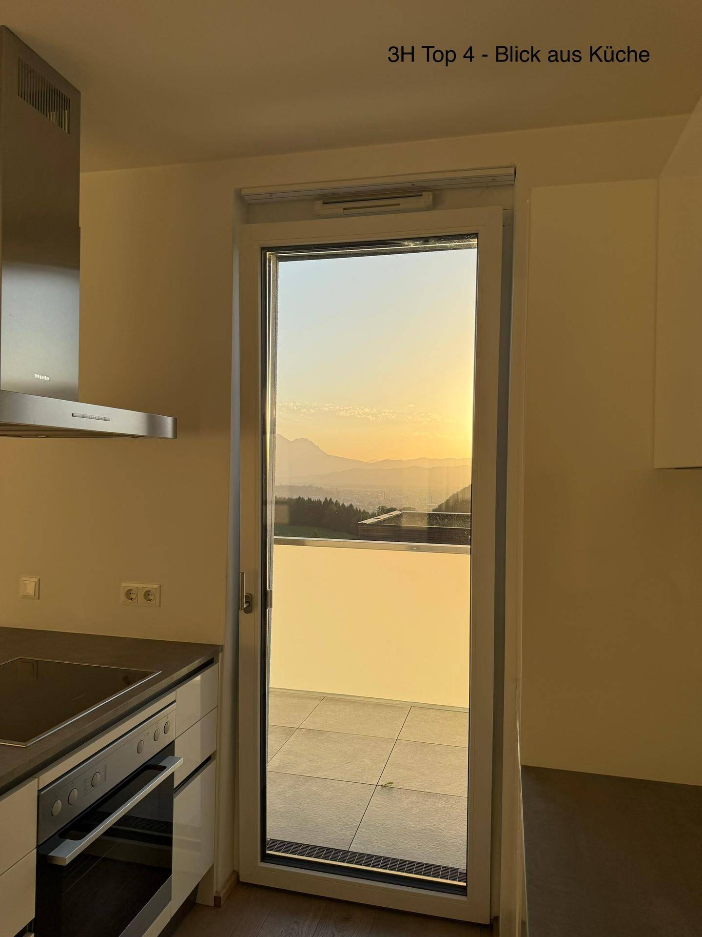Detailansicht der Küche mit Zugang zum Balkon und einem wunderschönen Sonnenuntergangsblick.