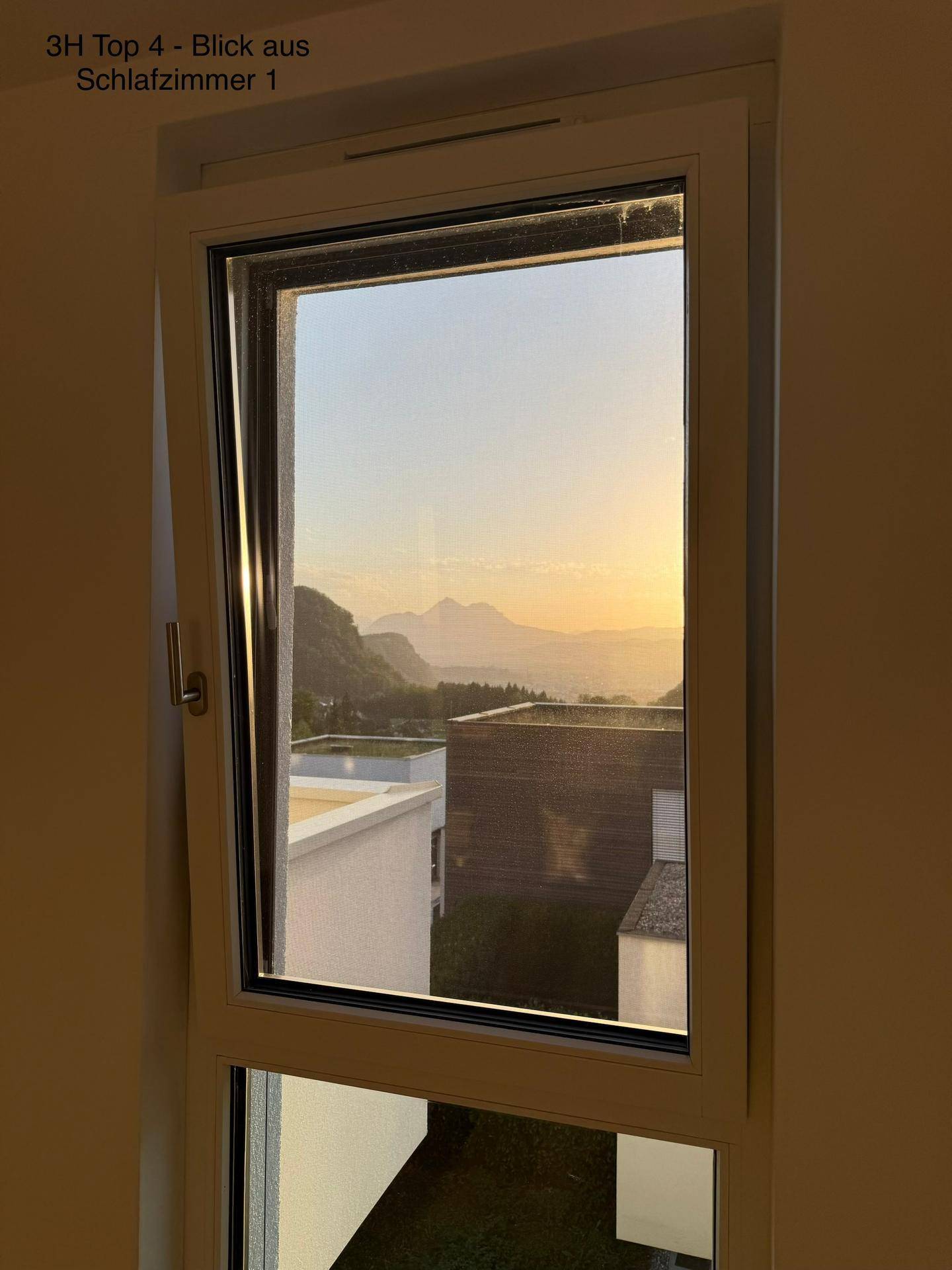 Malerischer Sonnenuntergangsblick aus dem Schlafzimmerfenster auf Berge und die umliegende Landschaft.