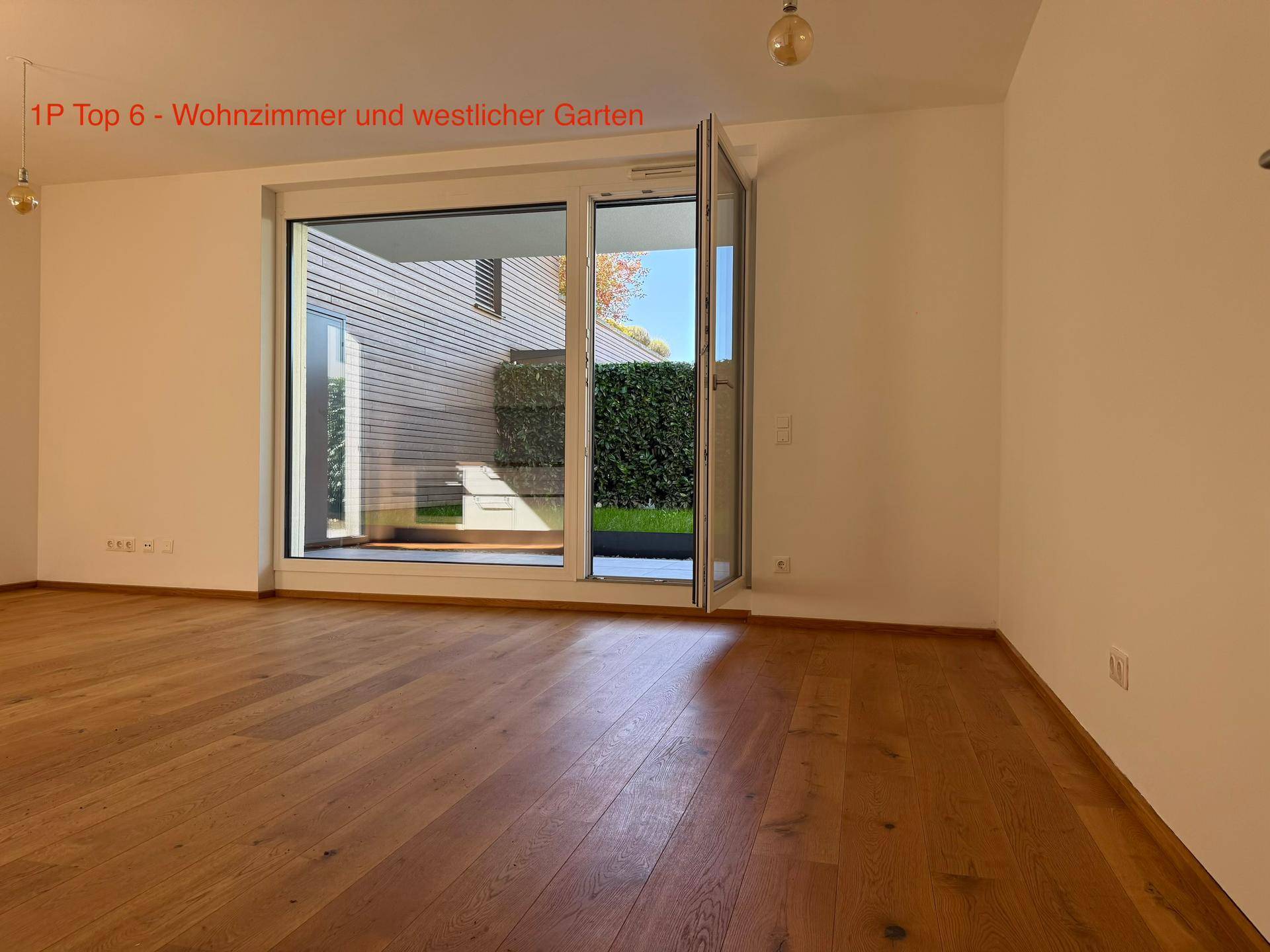 Helles Wohnzimmer mit Eichenparkett und großen Fenstern zum westlichen Gartenbereich.
