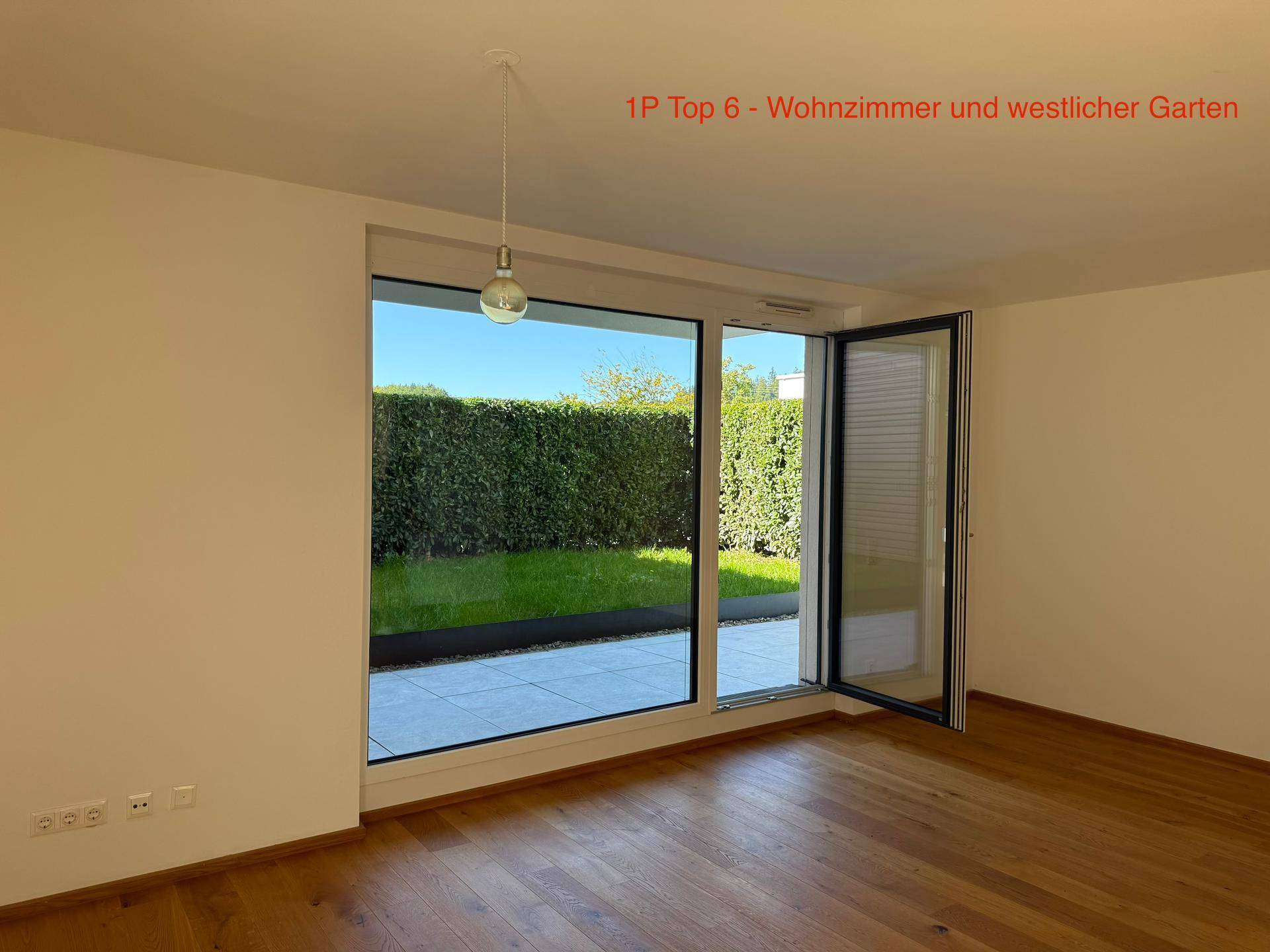 Lichtdurchflutetes Wohnzimmer mit Eichenparkett und weitem Blick auf den grünen Garten.