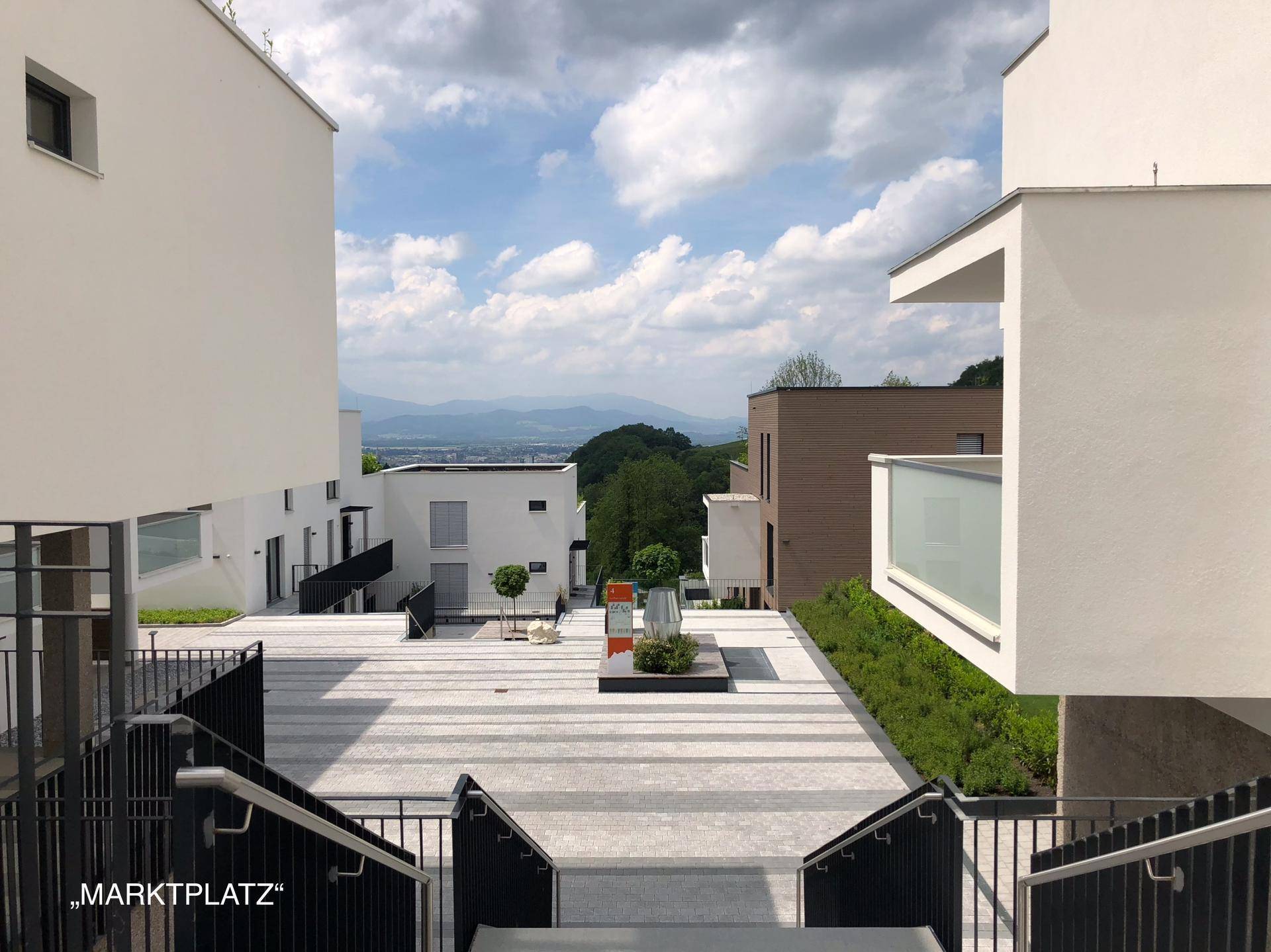 Heller Innenhof mit moderner Gestaltung und weitem Blick auf die umliegende Landschaft.