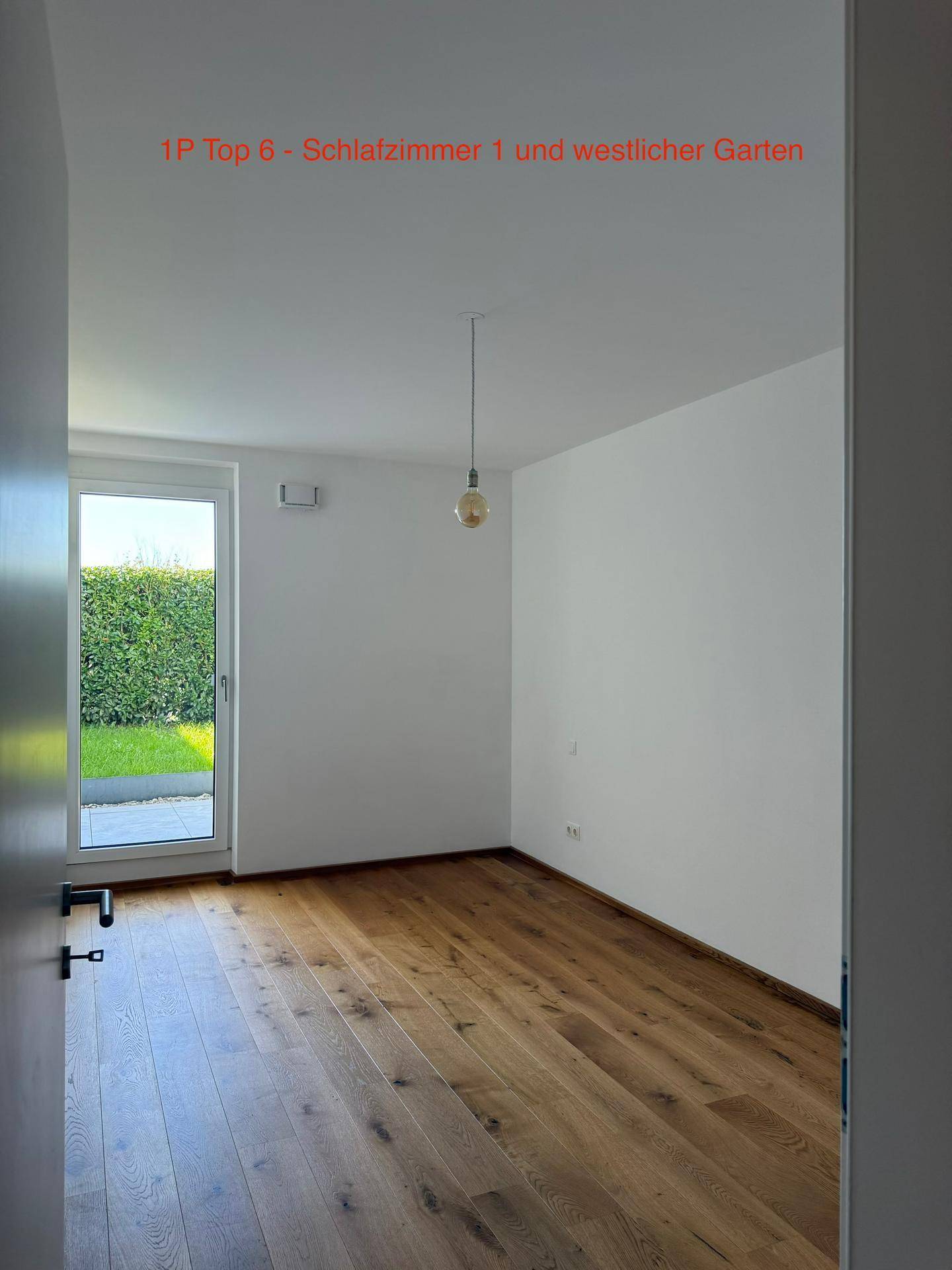 Helles Schlafzimmer mit Eichenparkettboden und direktem Zugang zum westlichen Gartenbereich.