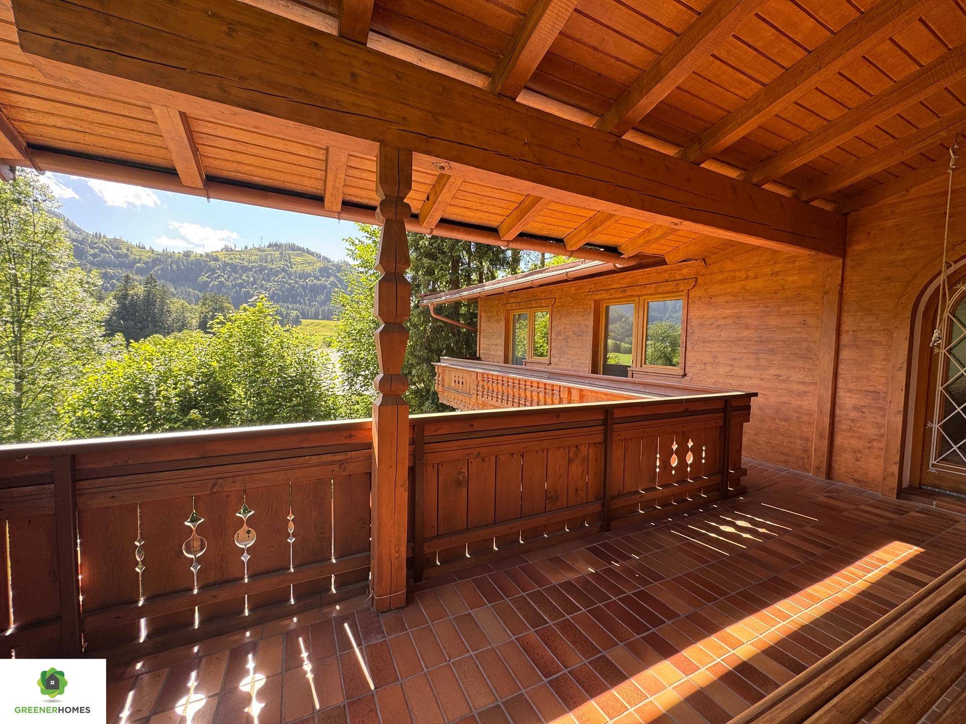 Überdachter Holzbalkon mit traditionellem Geländer und Fliesenboden, ideal zum Entspannen.