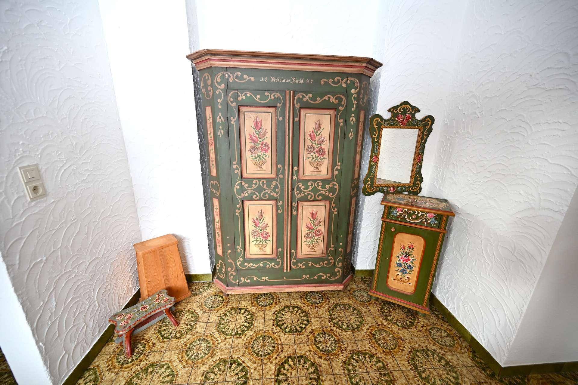 Flur mit einem traditionell bemalten Holzschrank und passendem Spiegel, sehr dekorativ.