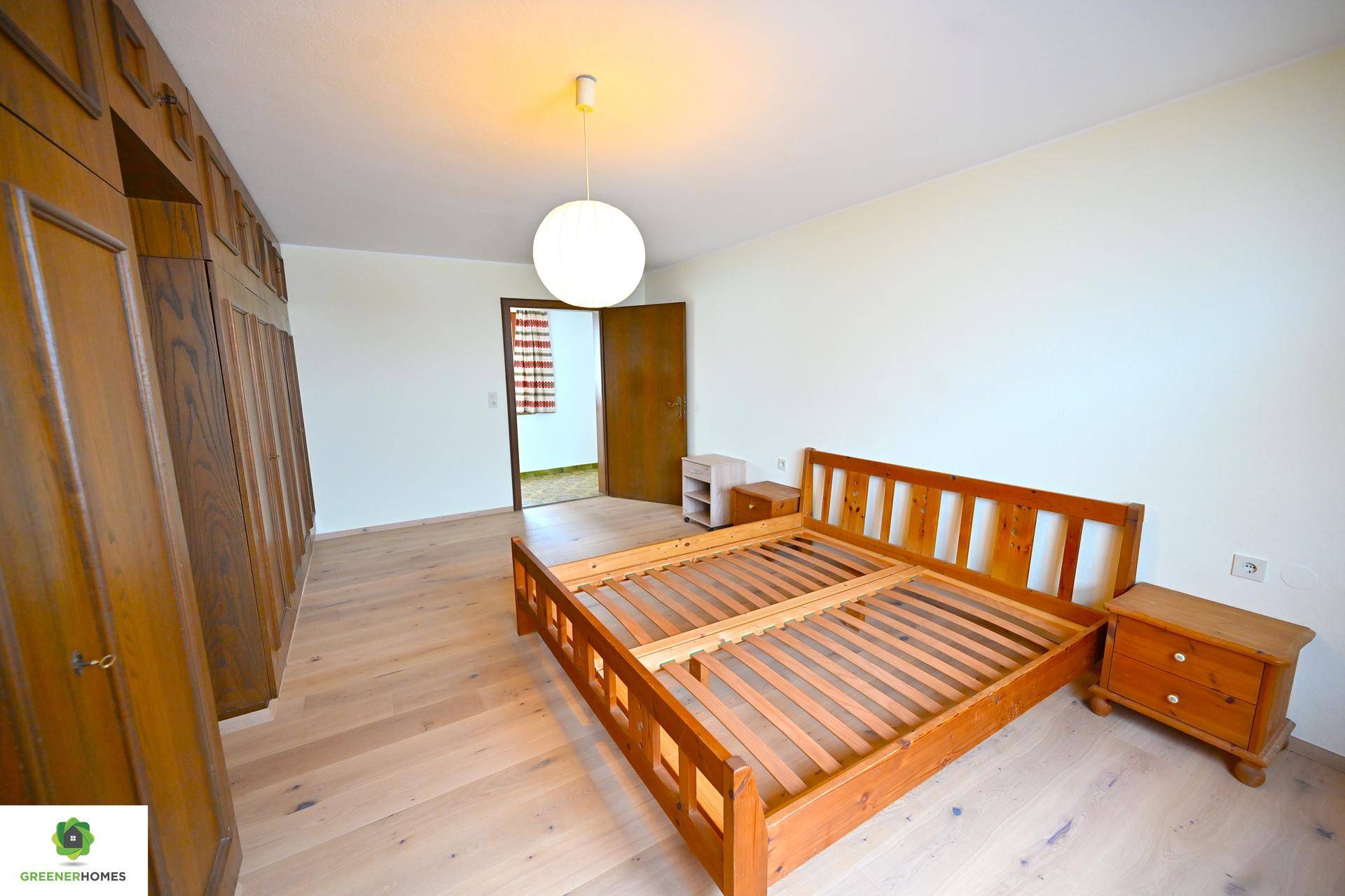 Schlafzimmer mit Holzbett, Nachttischen und großem Kleiderschrank, bietet viel Stauraum.