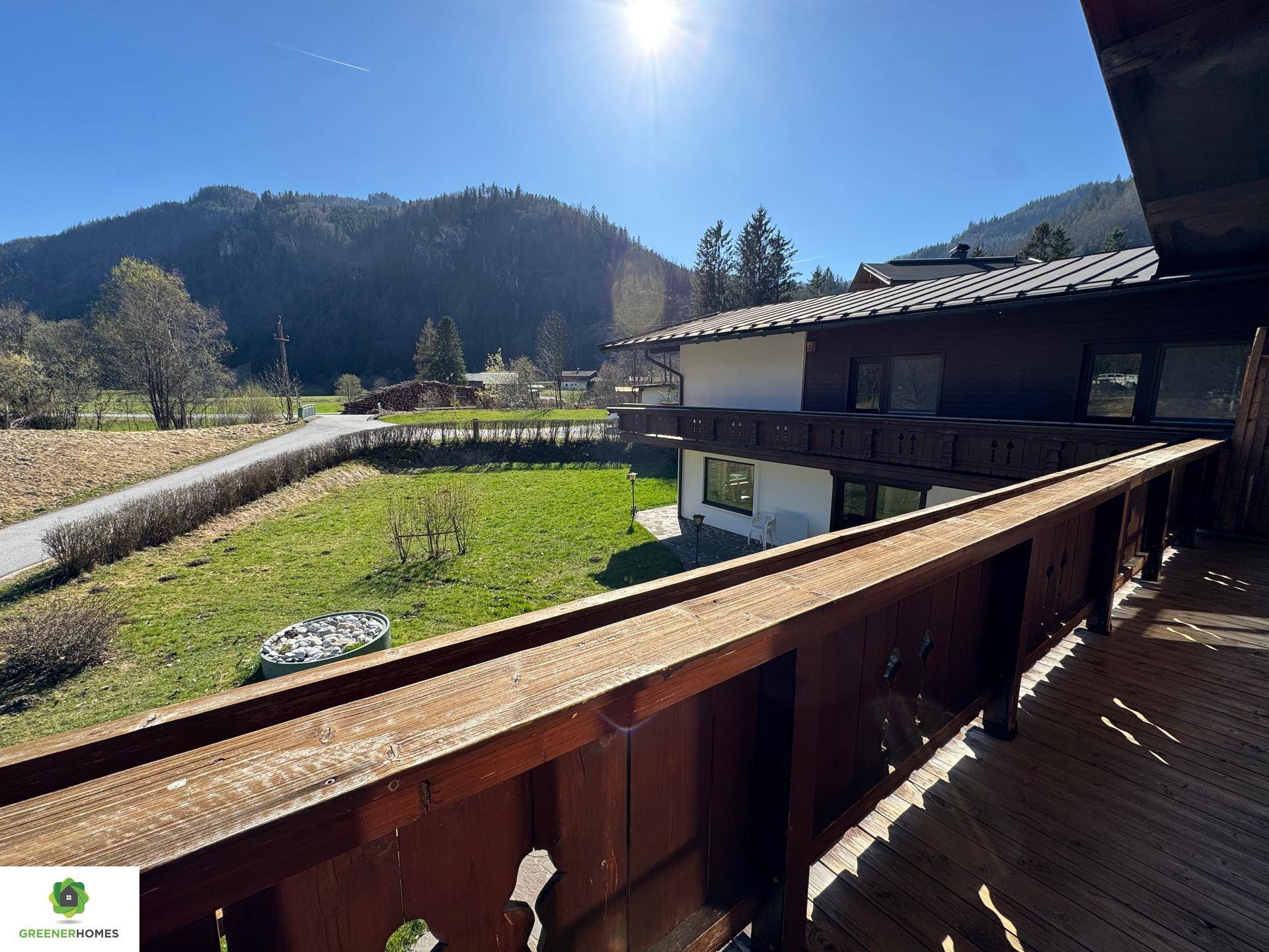 Großer Holzbalkon mit Bergblick und viel Sonnenschein.