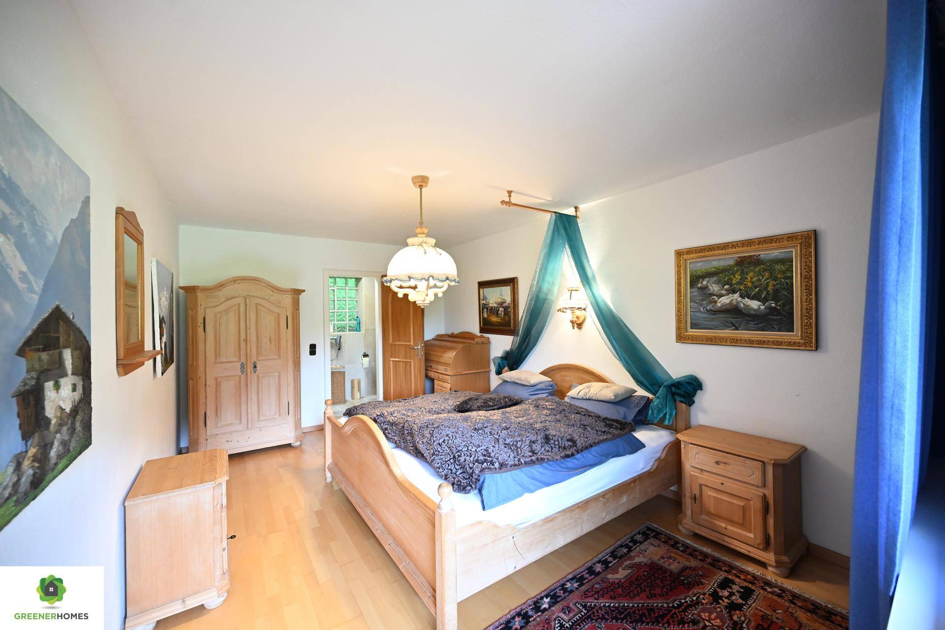 Geräumiges Schlafzimmer mit hellem Holzbett, Holzschränken und Zugang zu einem weiteren Raum.