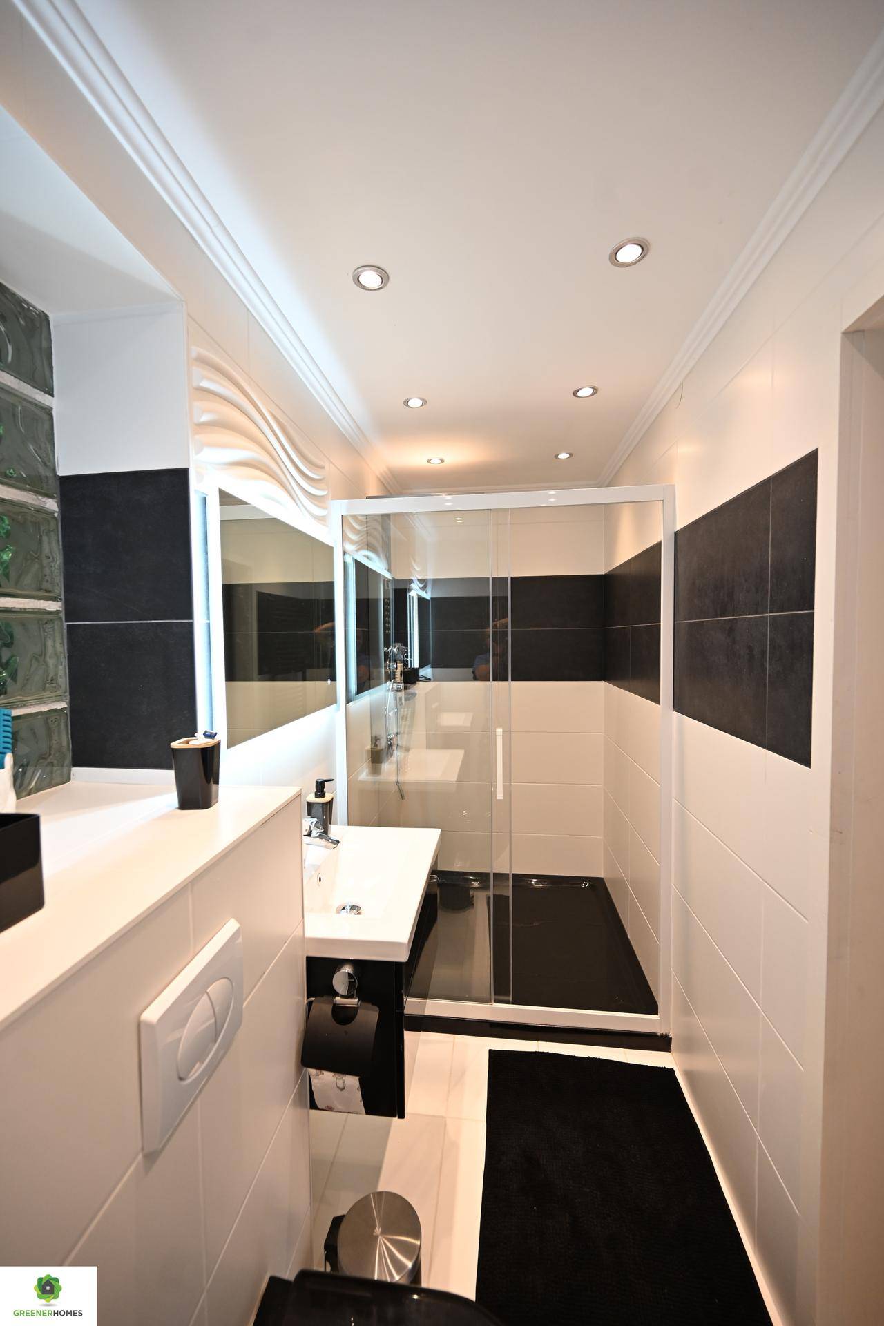 Modernes Gäste-WC mit schwarz-weißen Fliesen, Dusche und wandhängendem WC.