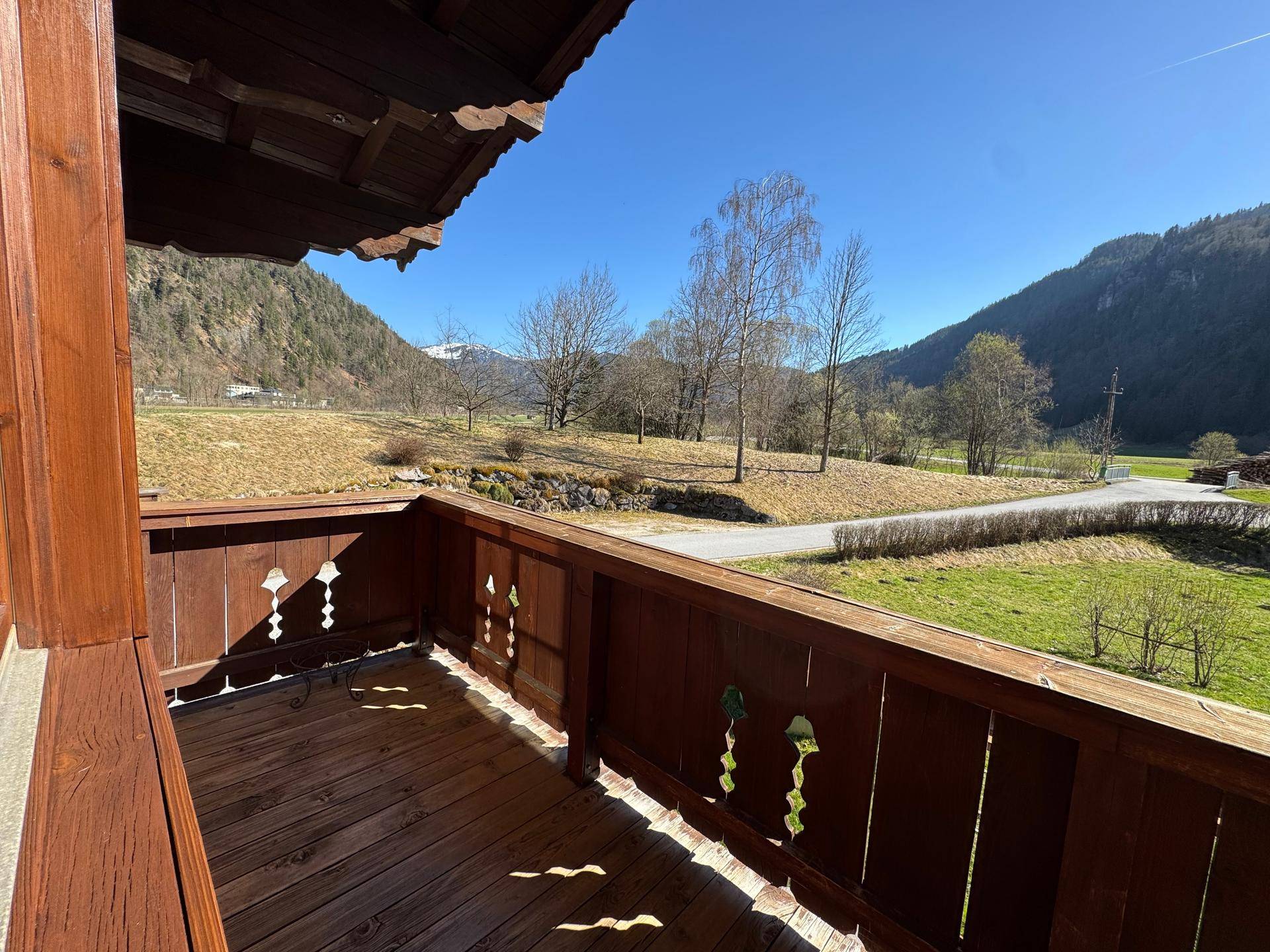 Traditioneller Holzbalkon mit weitem Blick auf die umliegende Natur und Berge.