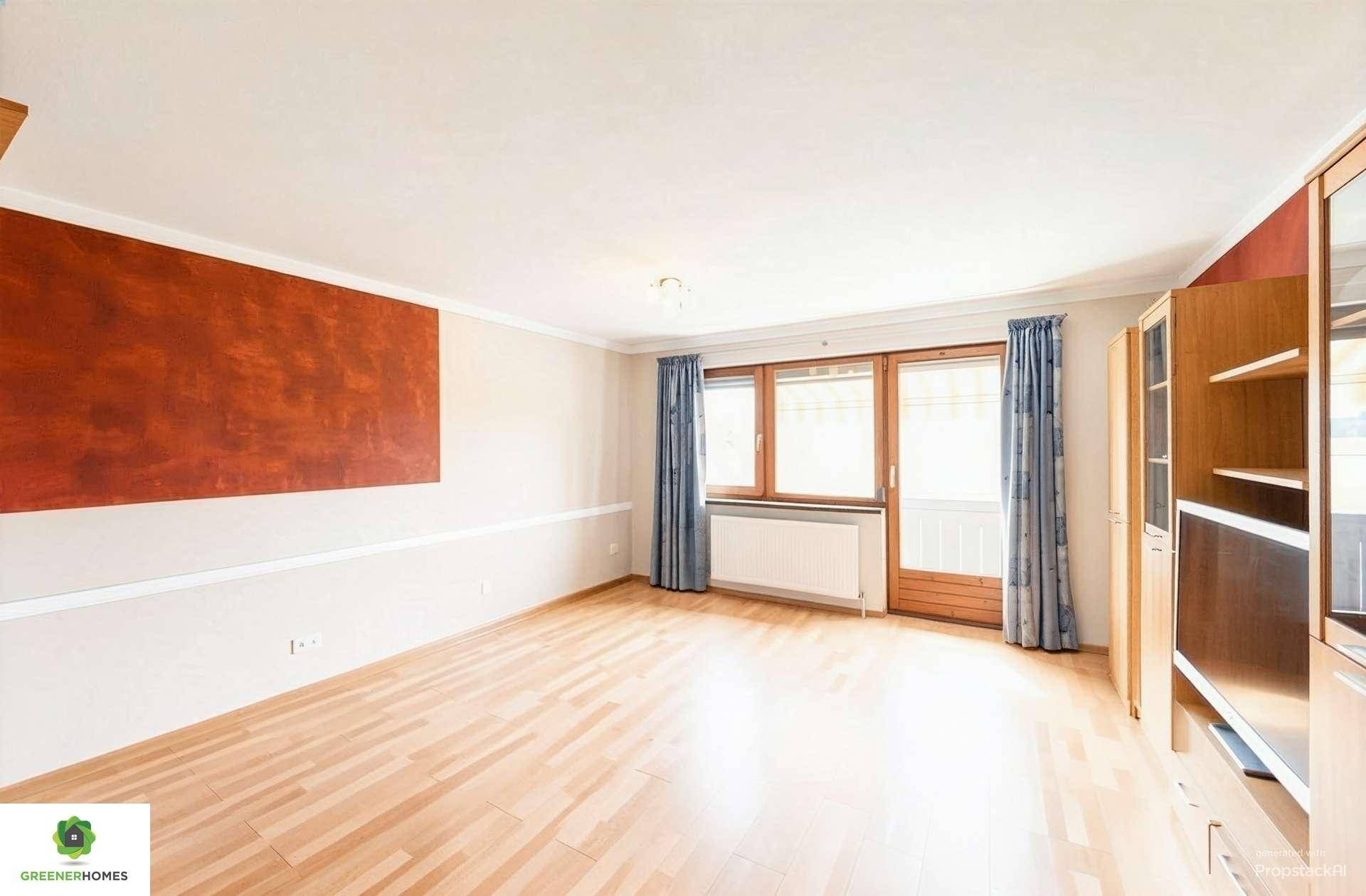 Helles Wohnzimmer mit Holzboden, einer Akzentwand und Zugang zu einem Balkon oder Terrasse.