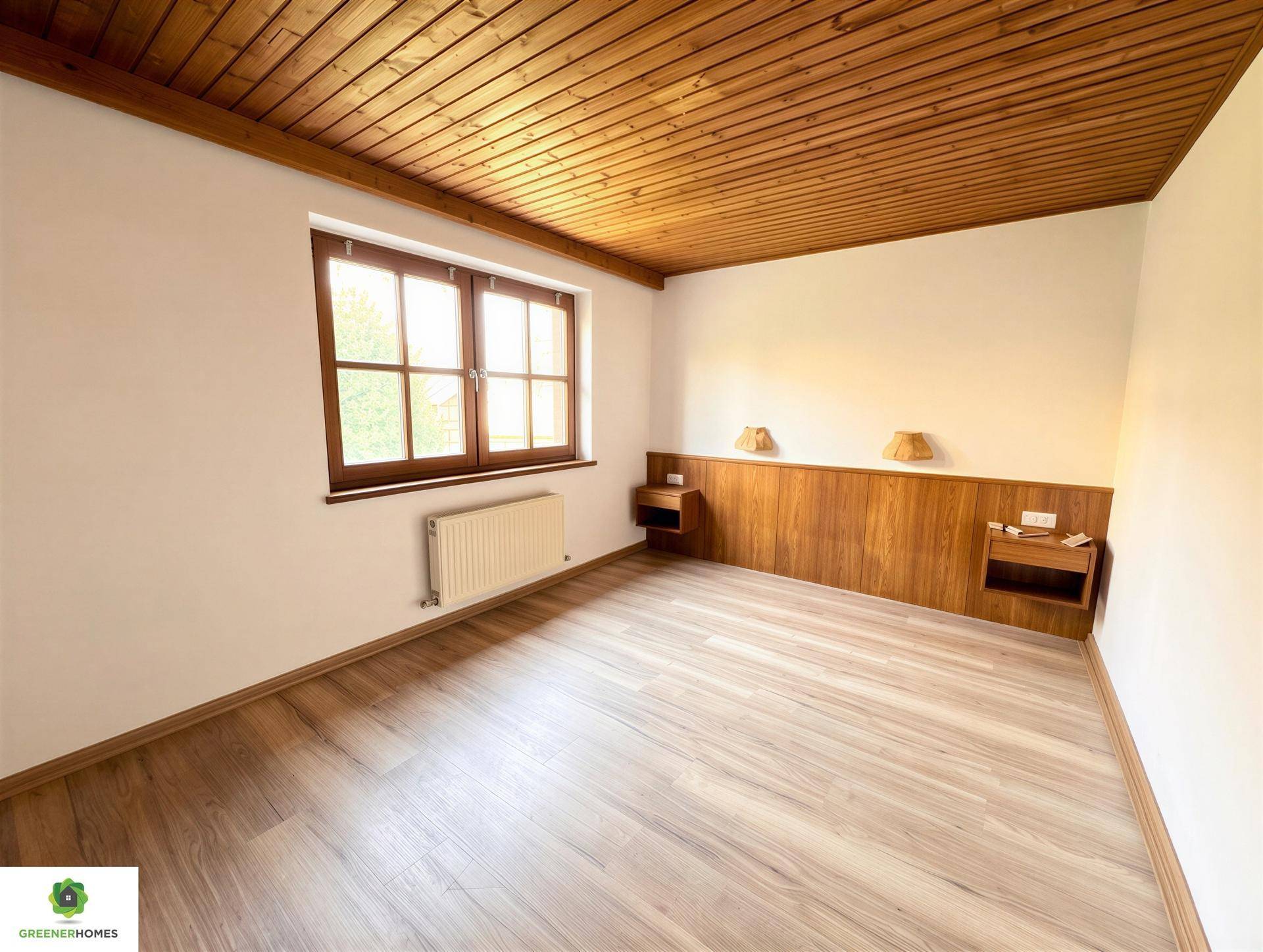 Schlafzimmer mit Holzbalkendecke, Holzakzenten und Laminatboden.
