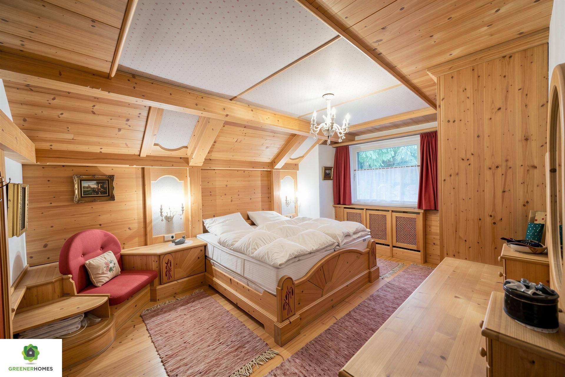 Charmantes Schlafzimmer mit Holzvertäfelung, Dachschräge und traditionellem Holzbett.