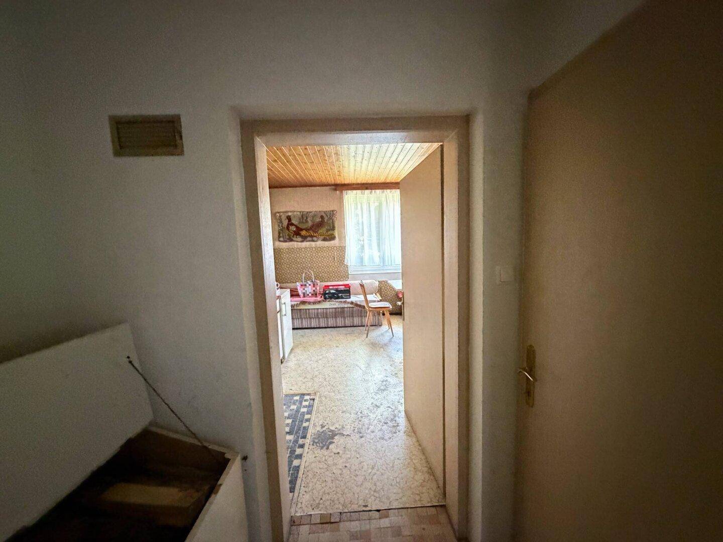 Blick durch eine Tür in eine traditionelle Wohnküche mit Holztäfelung.