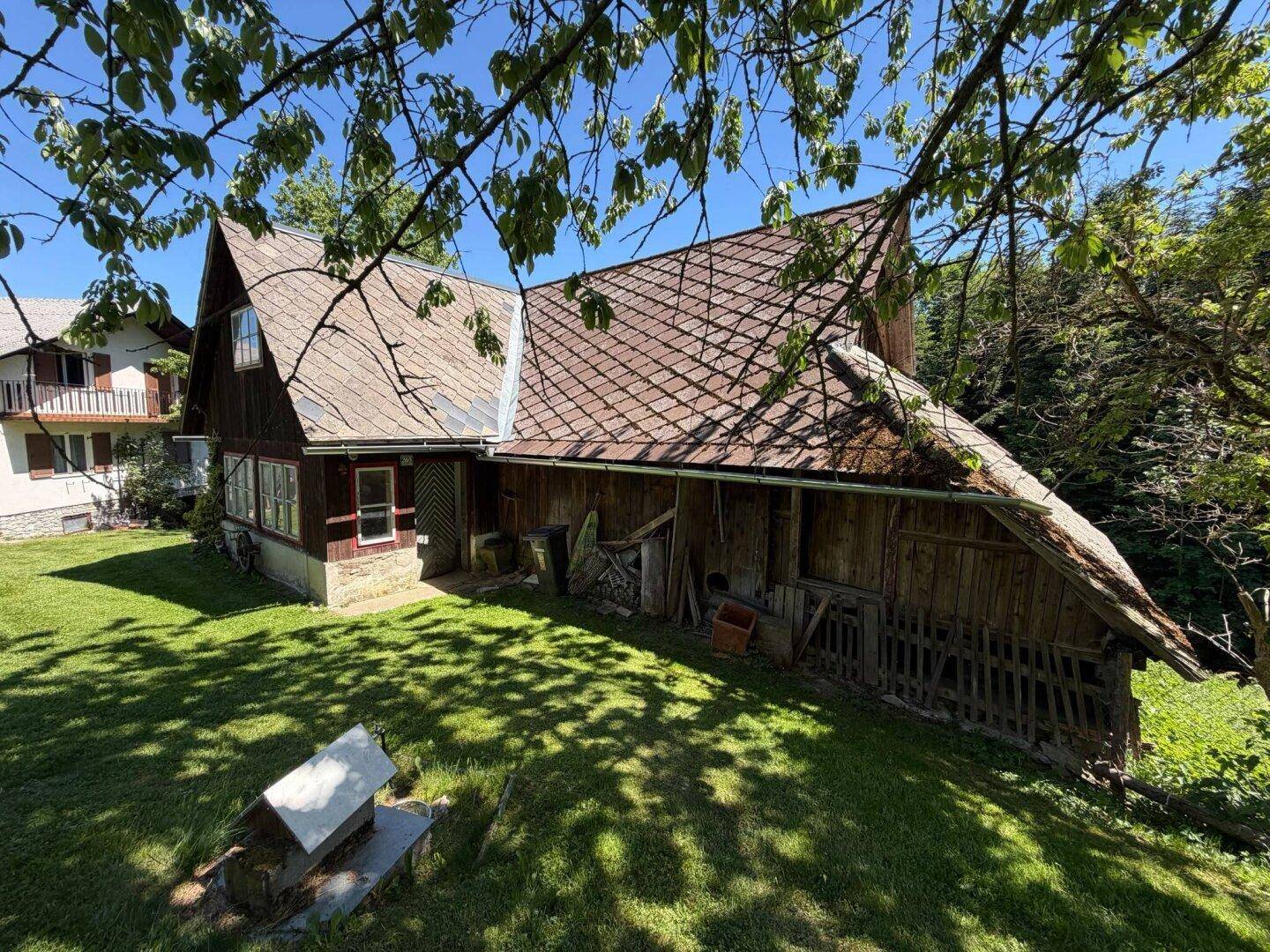 Rustikales Haus mit traditionellem Dach und gepflegtem Rasen in ländlicher Umgebung.