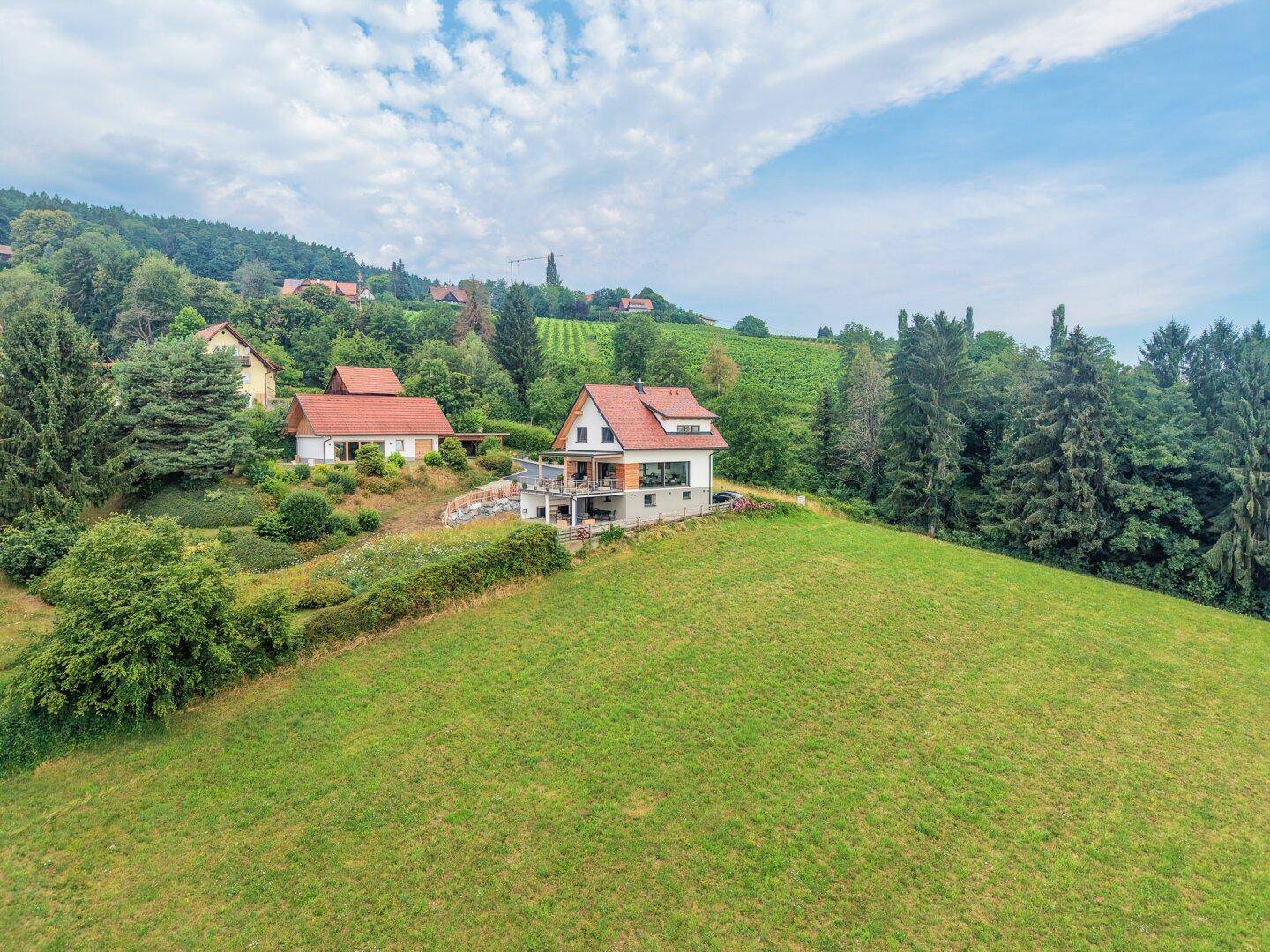Haus in idyllischer Hanglage mit weitem Blick über die grüne Hügellandschaft.