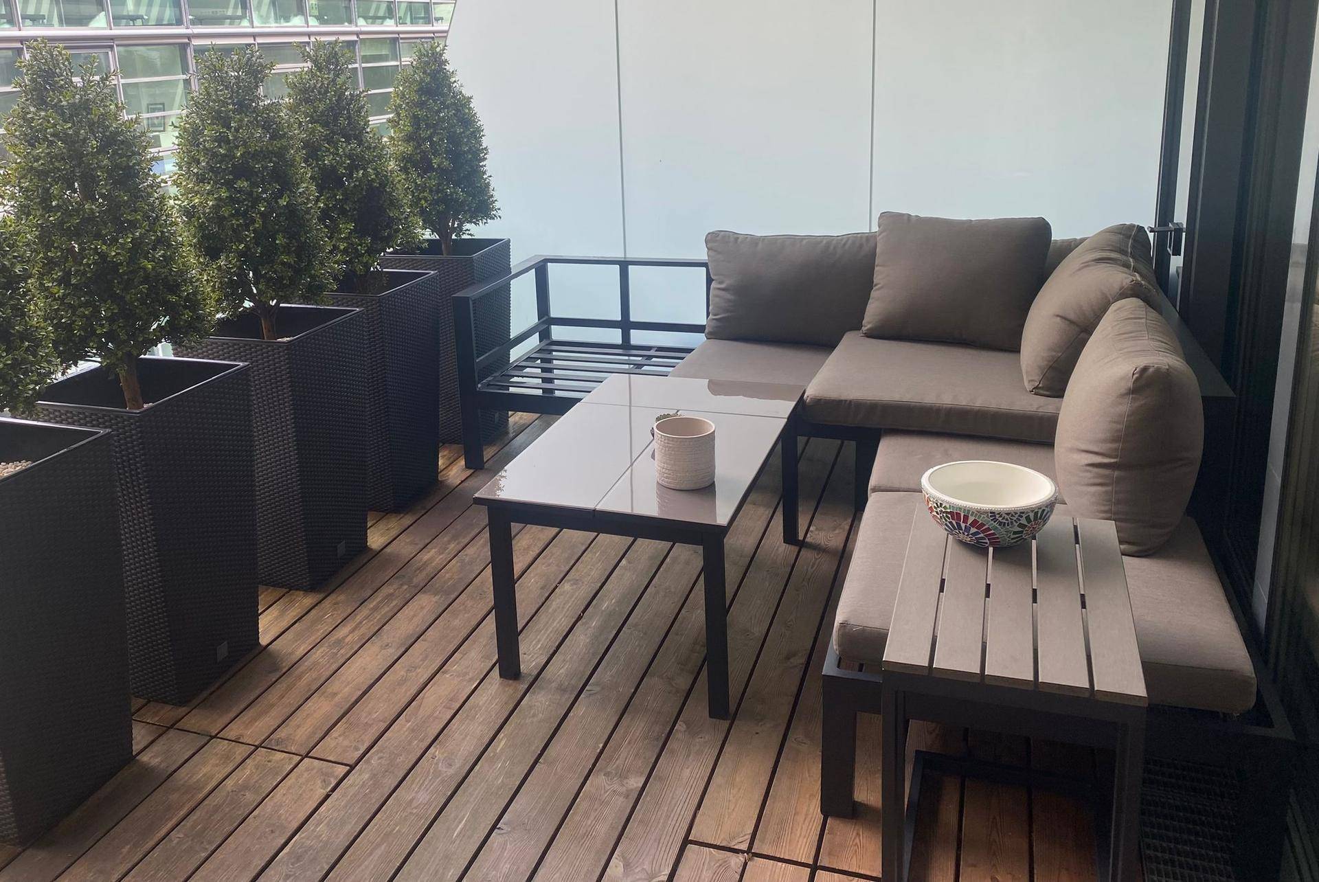 Gemütlicher Balkon mit bequemen Outdoor-Möbeln und dekorativen Topfpflanzen.