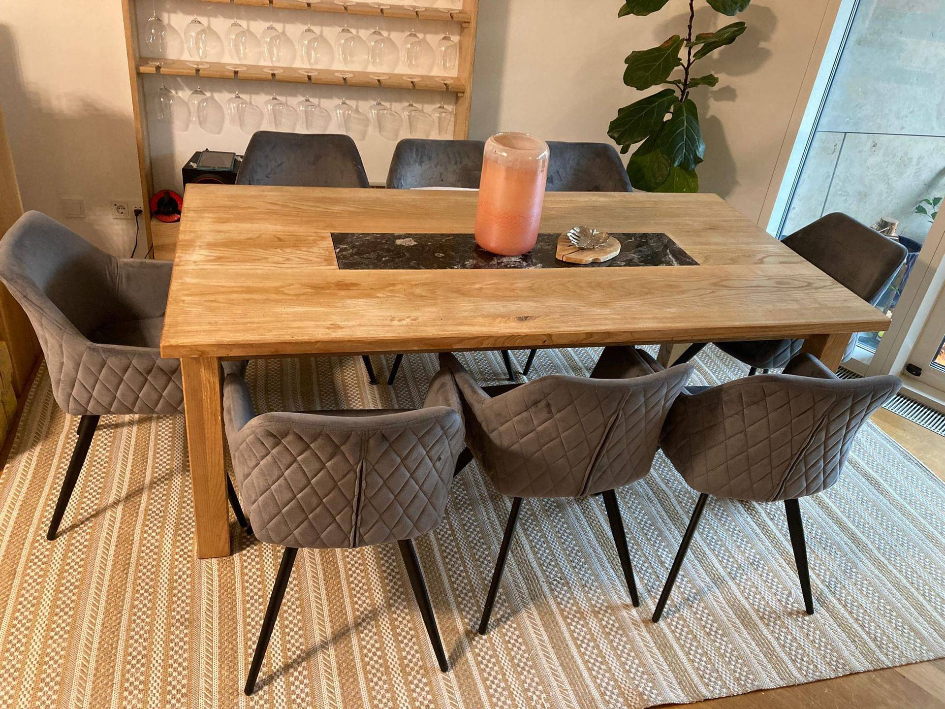 Eleganter Essbereich mit Holztisch, bequemen Polsterstühlen und einem gemusterten Teppich.