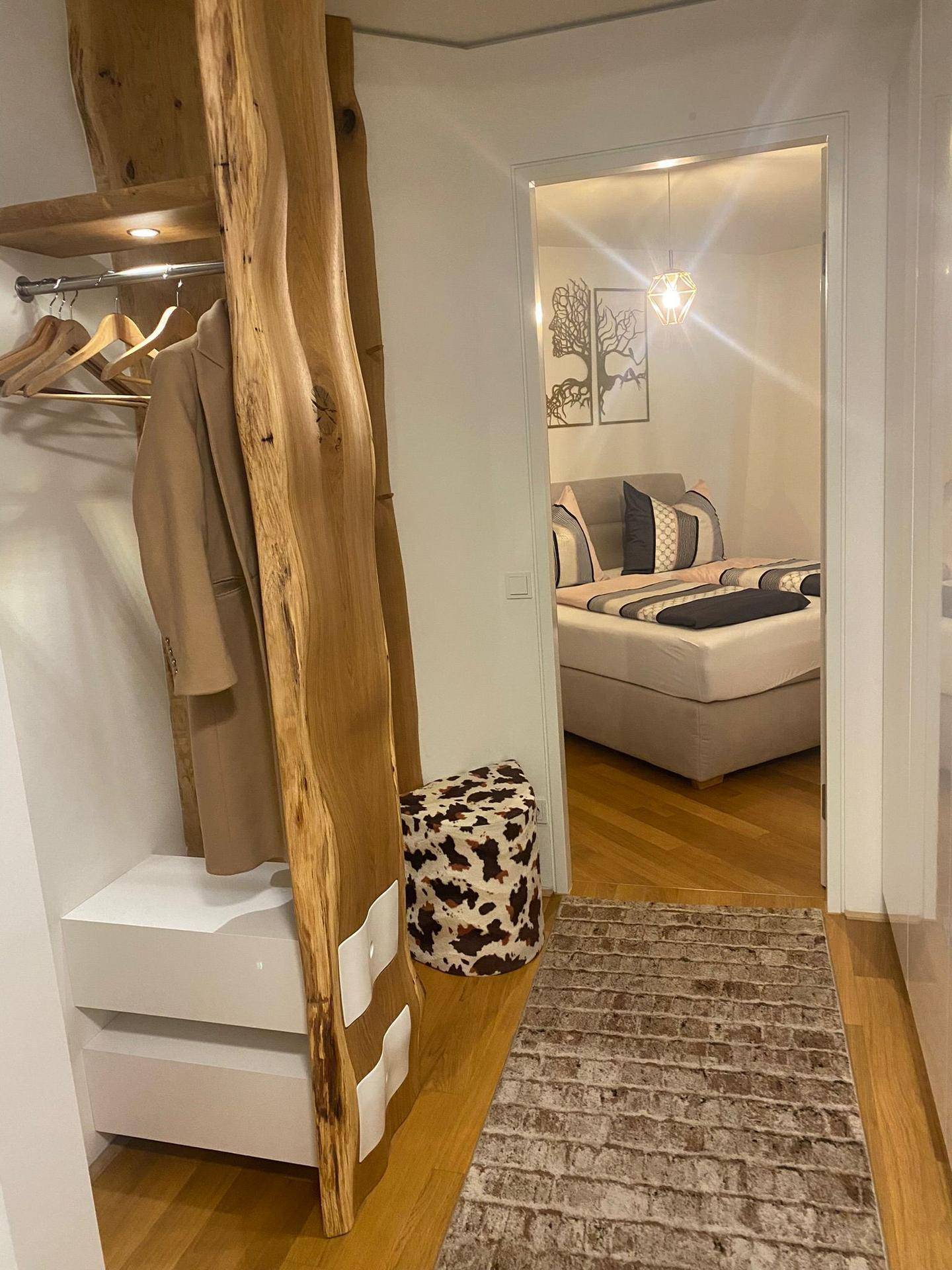 Heller Flur mit maßgefertigter Garderobe aus Naturholz, die zum Schlafzimmer führt.