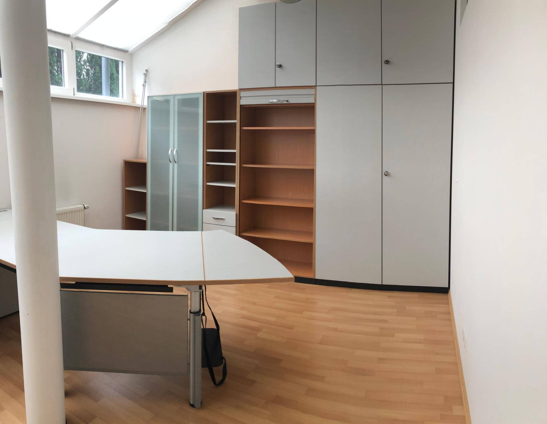 Büro mit integrierten Schränken und Regalen, bietet viel Stauraum und eine organisierte Arbeitsumgebung.