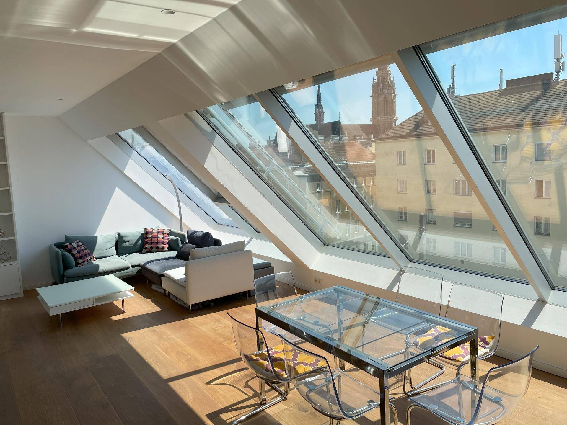 Lichtdurchfluteter Wohn- und Essbereich mit großen Dachfenstern und Stadtblick.