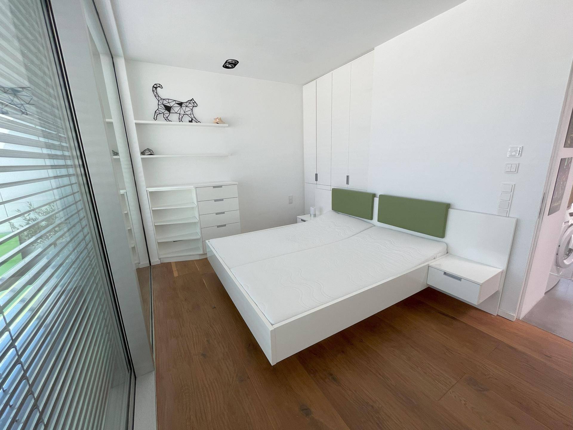 Modernes Schlafzimmer mit Einbauschränken, schwebendem Bett und Holzboden.