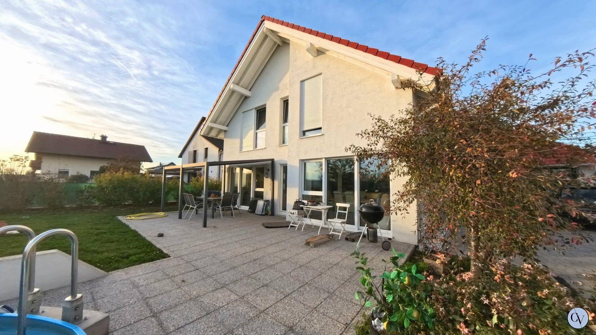 Große gepflasterte Terrasse mit Gartenmöbeln und Blick auf den Garten und das Haus.