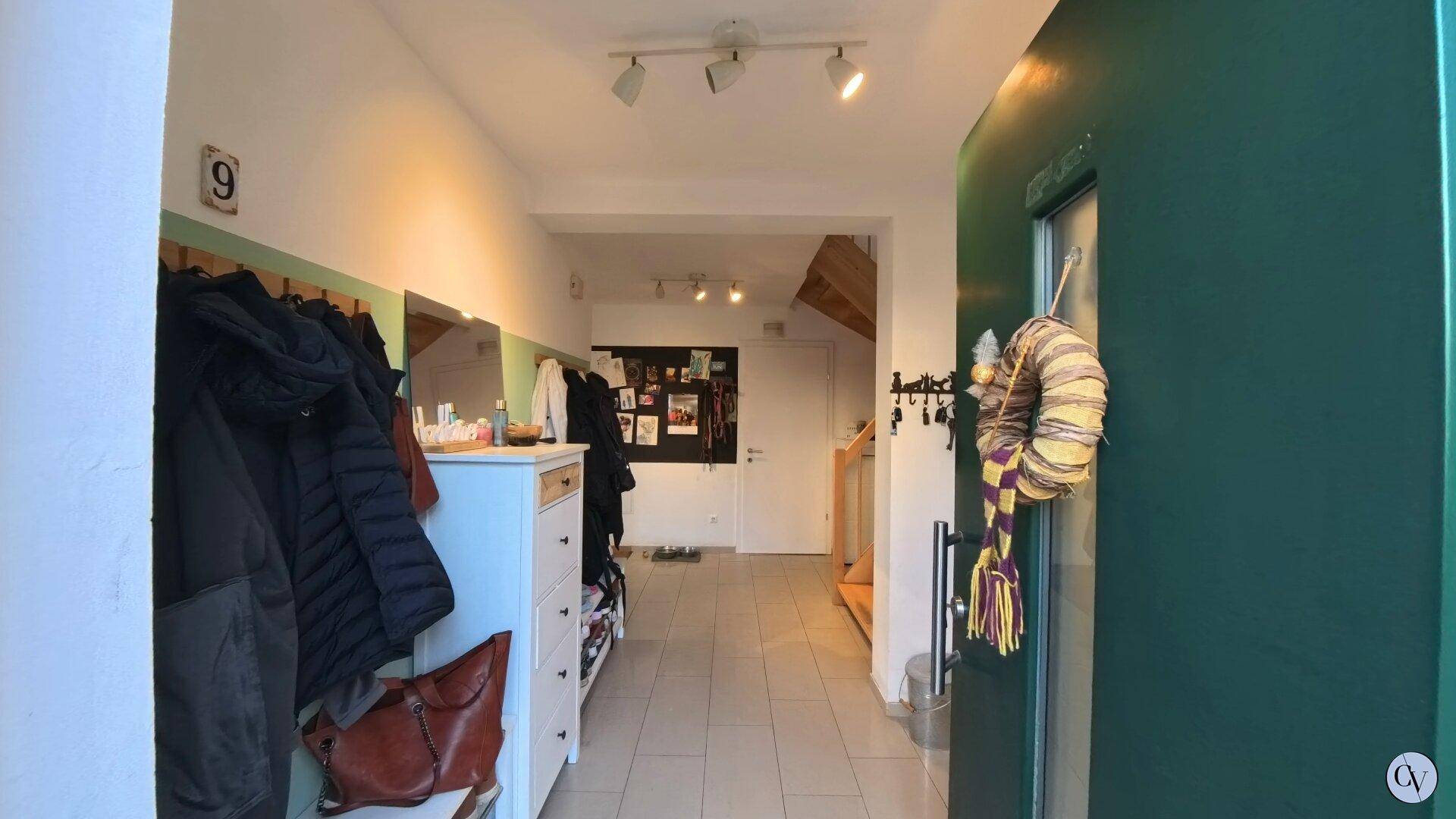 Eingangsbereich mit Garderobe, Fliesenboden und Blick in den hinteren Bereich des Hauses.