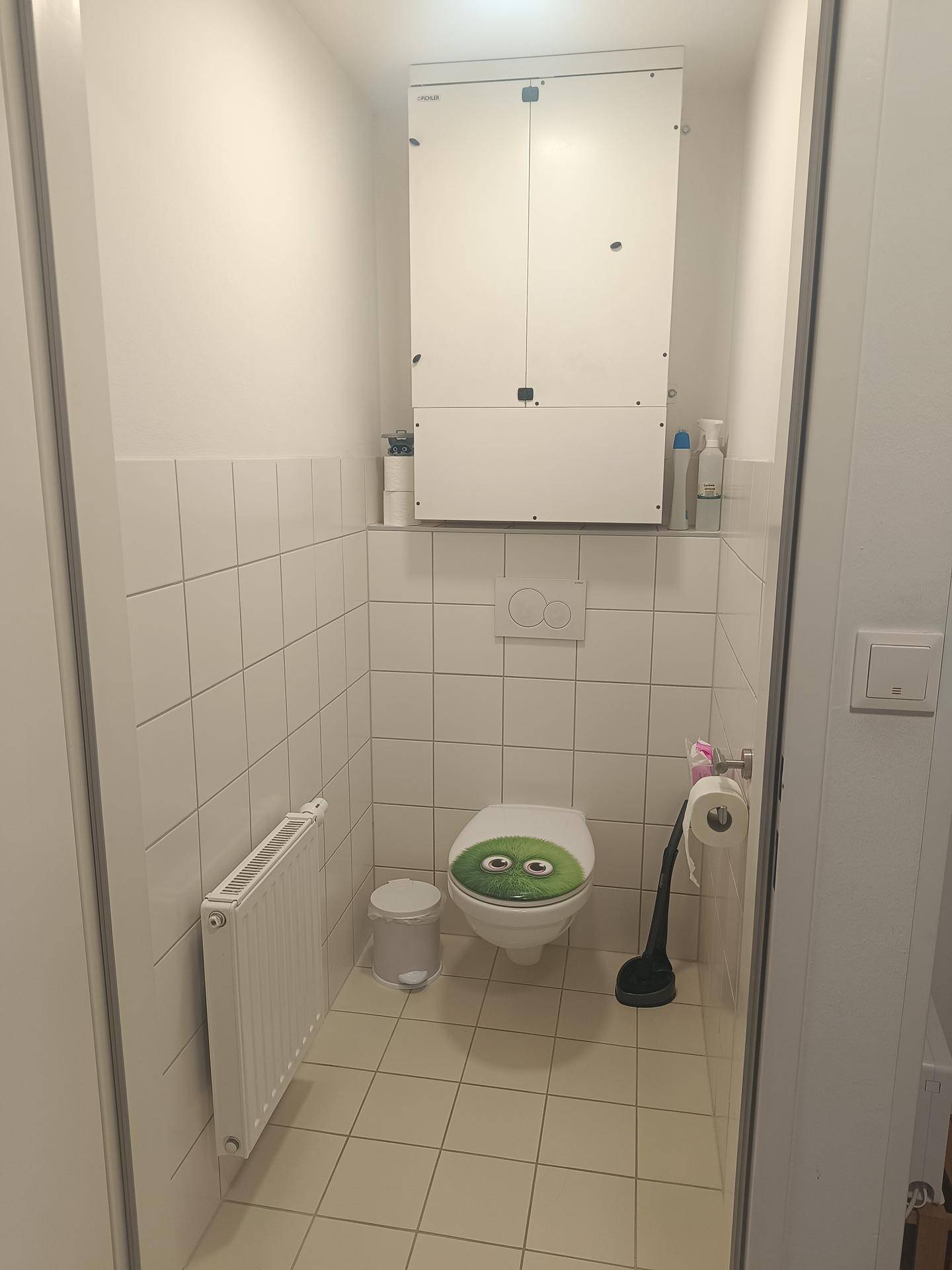 Separates WC mit Fliesenboden und Heizkörper, praktisch und funktional gestaltet.