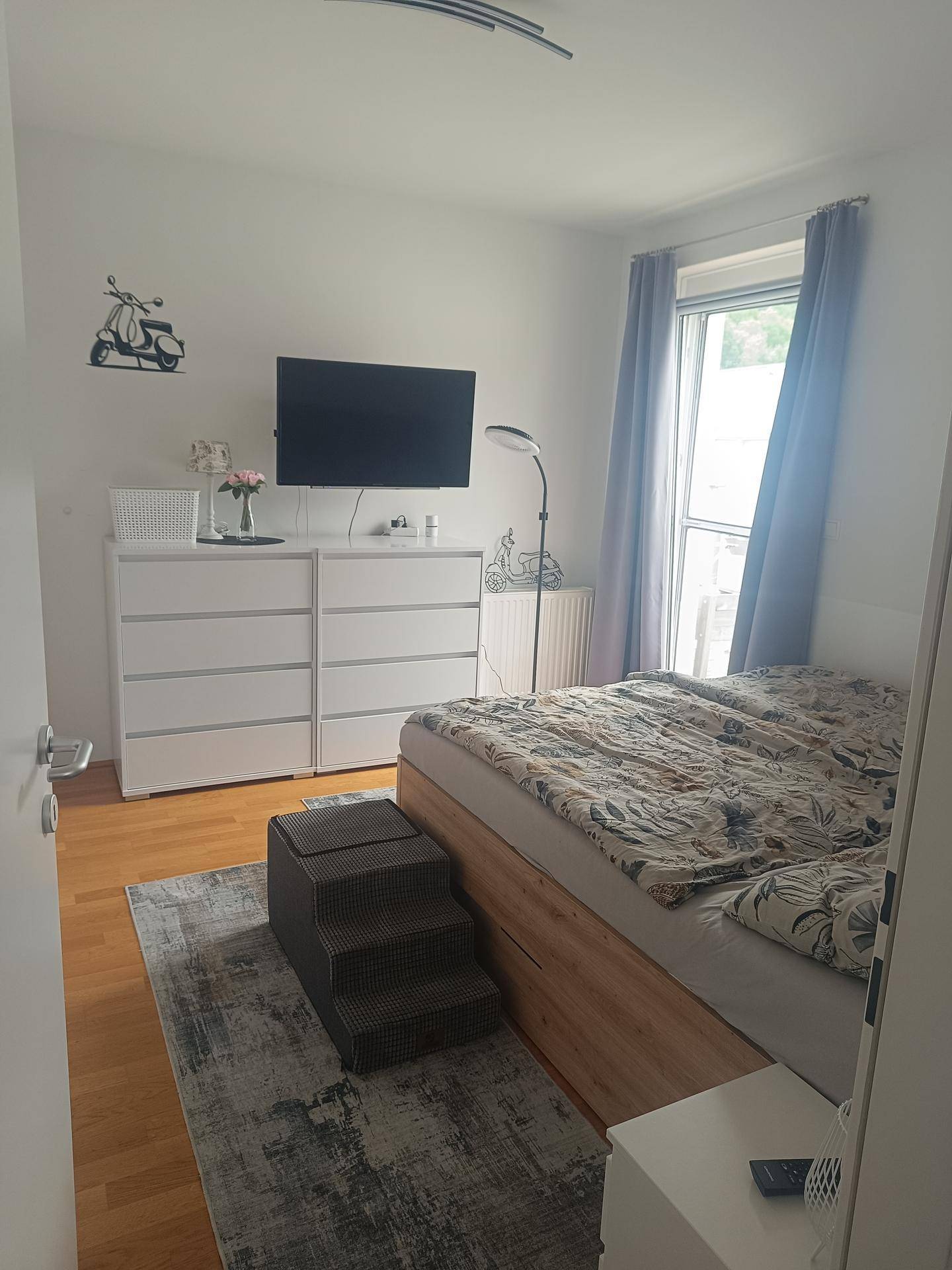 Gemütliches Schlafzimmer mit Holzboden, viel Stauraum und direktem Zugang zum Außenbereich.