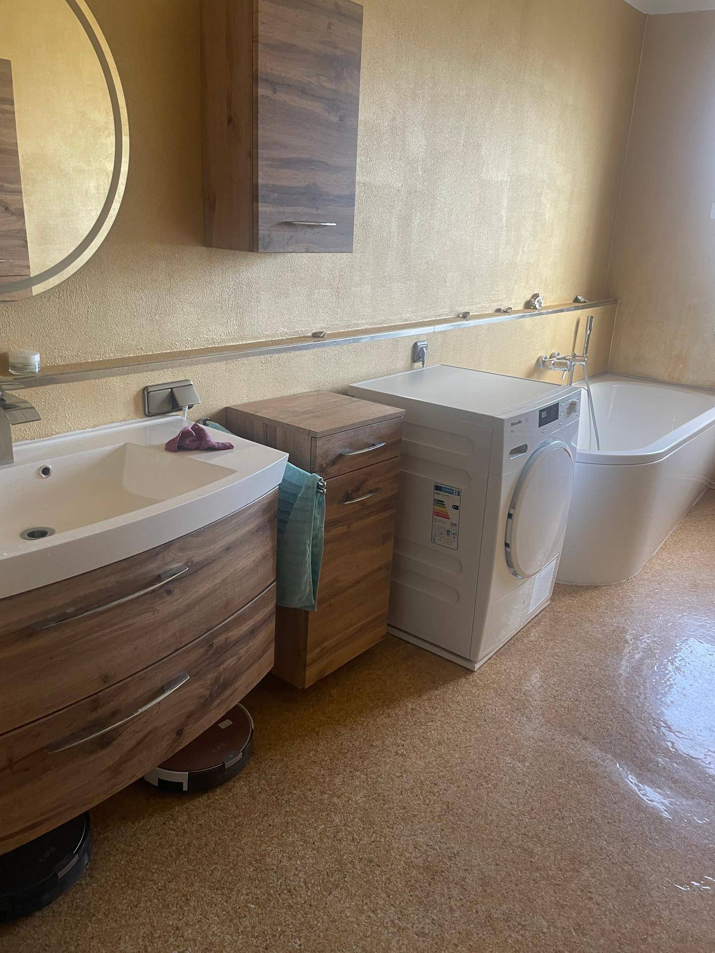 Badezimmer mit Badewanne, modernem Waschbecken und integrierter Waschmaschine für praktische Nutzung.