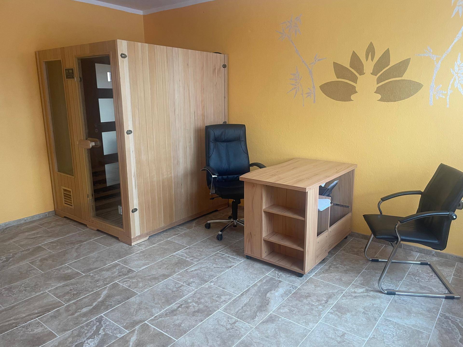 Vielseitiger Raum mit einer Sauna und einem Arbeitsbereich, ideal für Wellness und Home-Office.